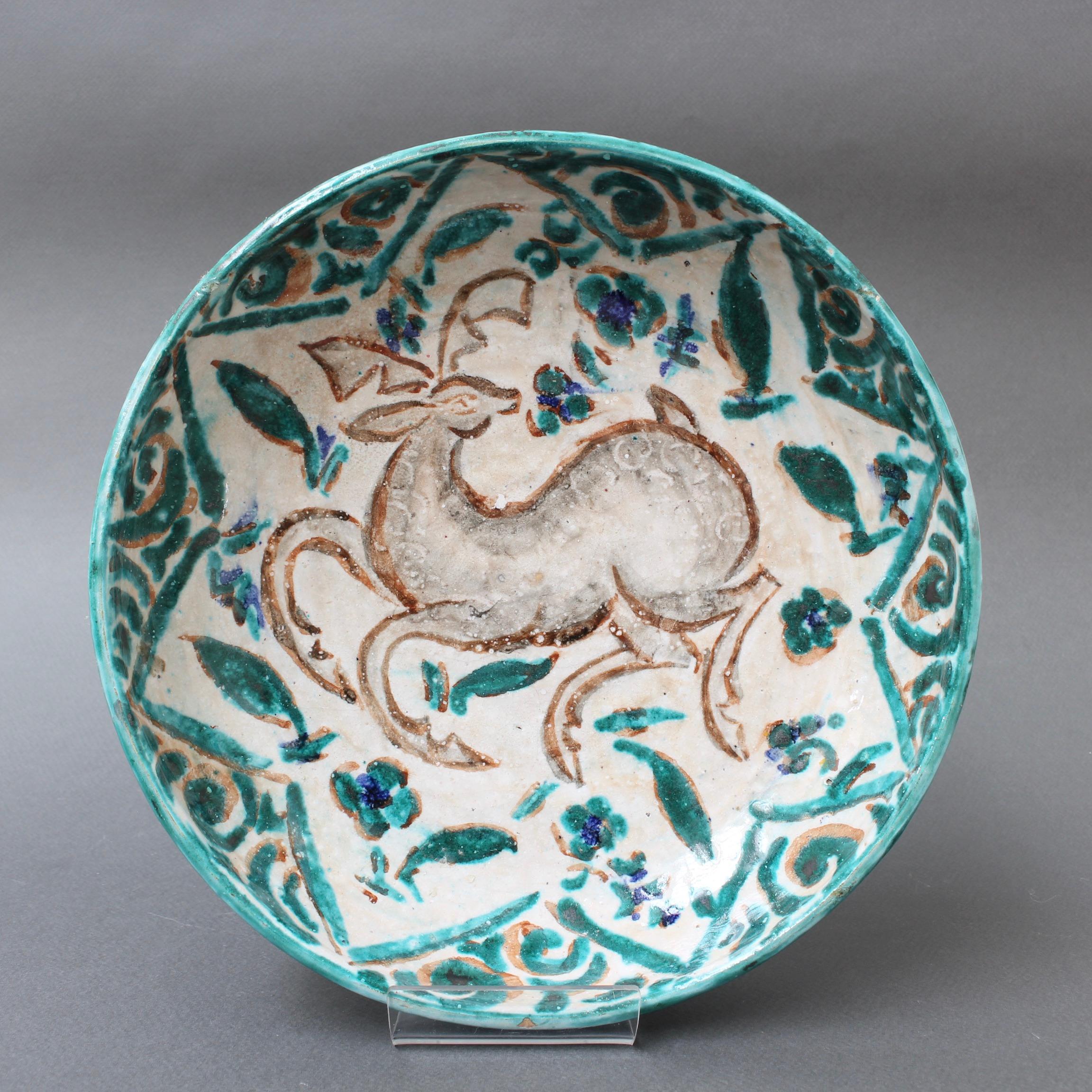 French Persian-inspired ceramic bowl by Édouard Cazaux (circa 1930s). Master ceramicist, Édouard Cazaux was inspired by antiquities, religion and animal life in his creations. This magnificently decorated ceramic bowl displays a stylised prancing