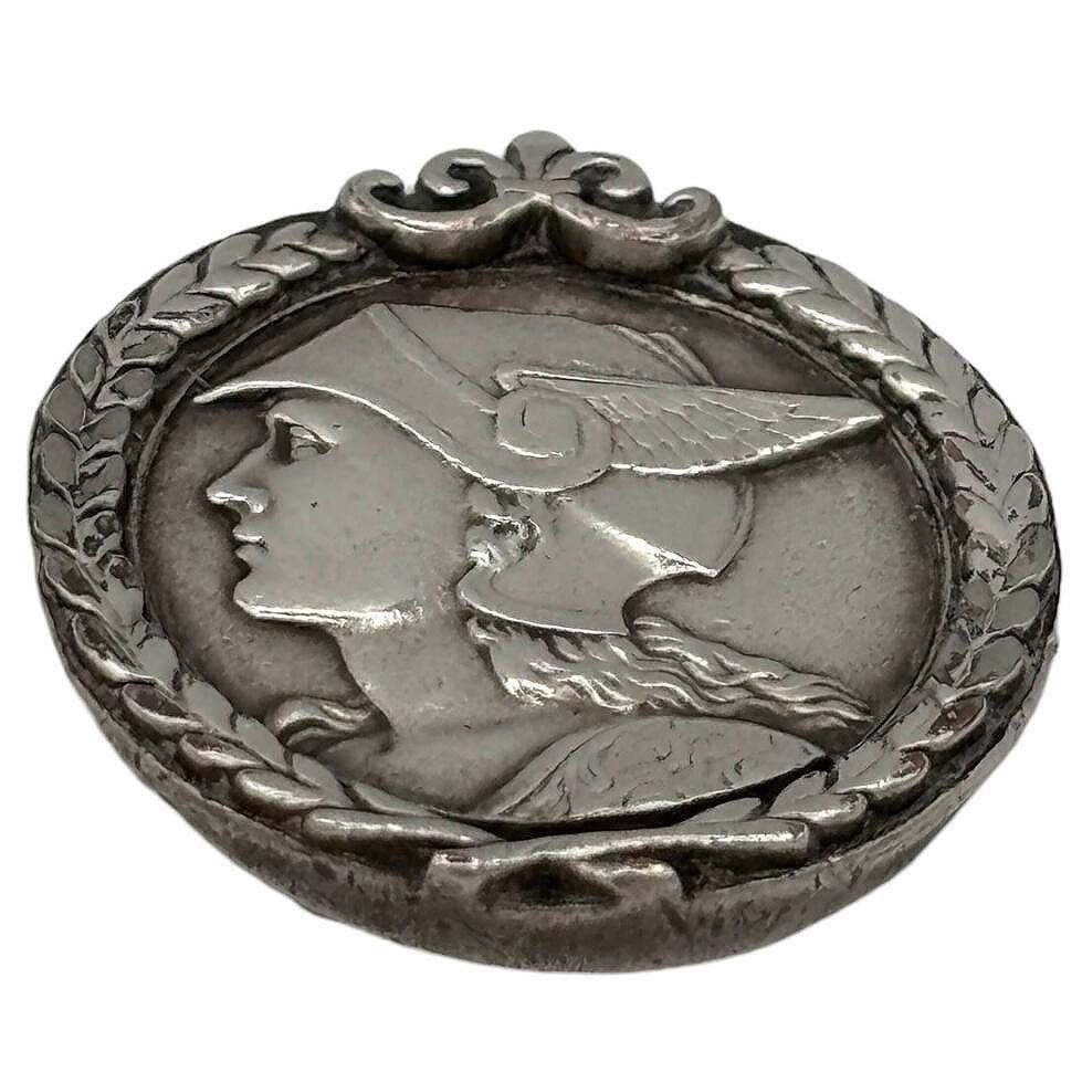 French Art Deco pewter medallion struck with the face of mercury pedant. The finely detailed design captures the regal presence of the Greek god Hermes (Mercury), rendered in an Art Deco style. Its timeless aesthetic makes it a versatile accessory,