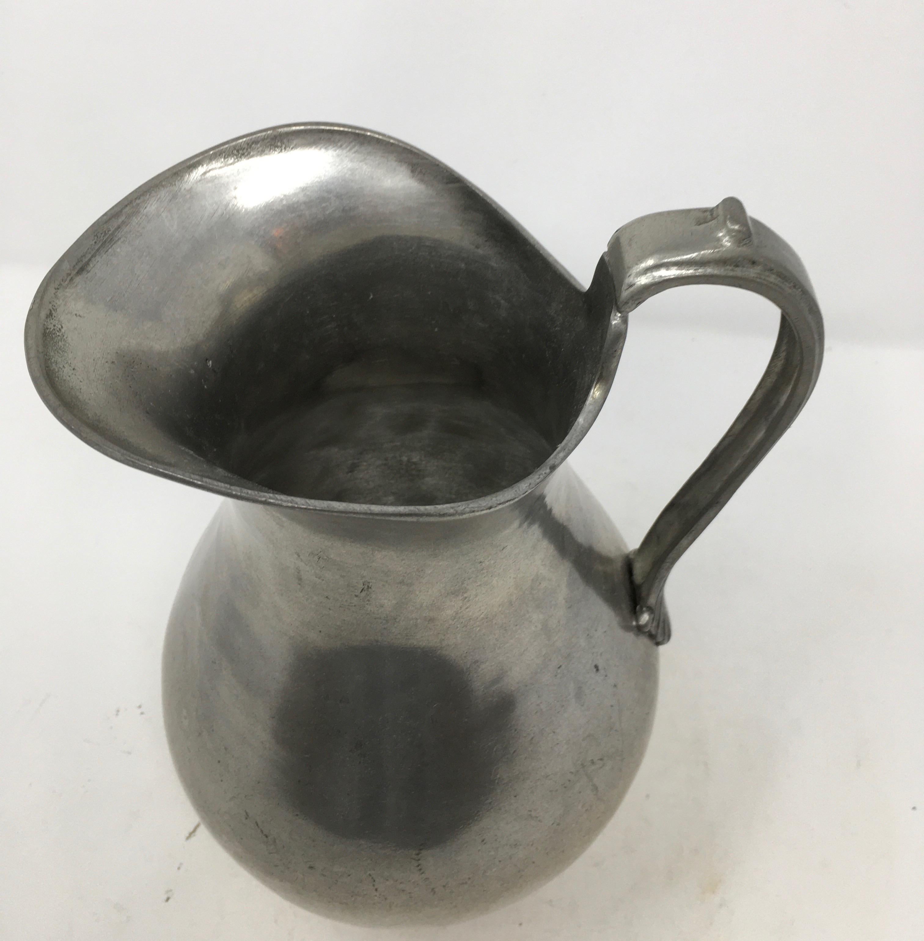 This French pewter pitcher is a classic, simple design. With its graceful shape, it would add beauty used for water, flowers or just as a decorative object. It has a mark on the bottom, but due to the age of the piece, it cannot be read. This piece