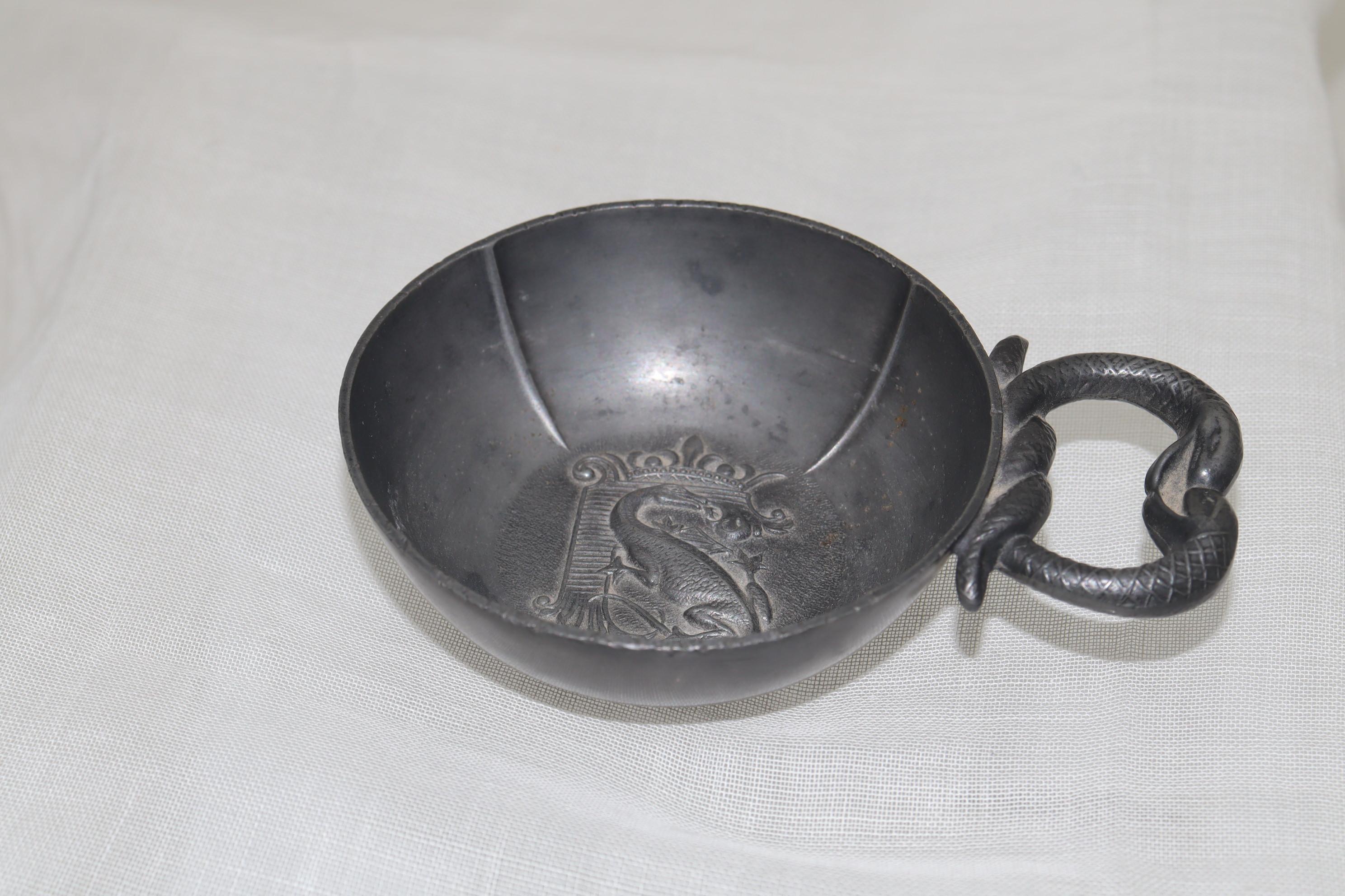 This good quality French pewter wine taster features a coat of arms to the centre, which consists of a fire-breathing salamander entwined around the letter F to the centre, all below a crown. This device was the emblem of Francois 1 of France who