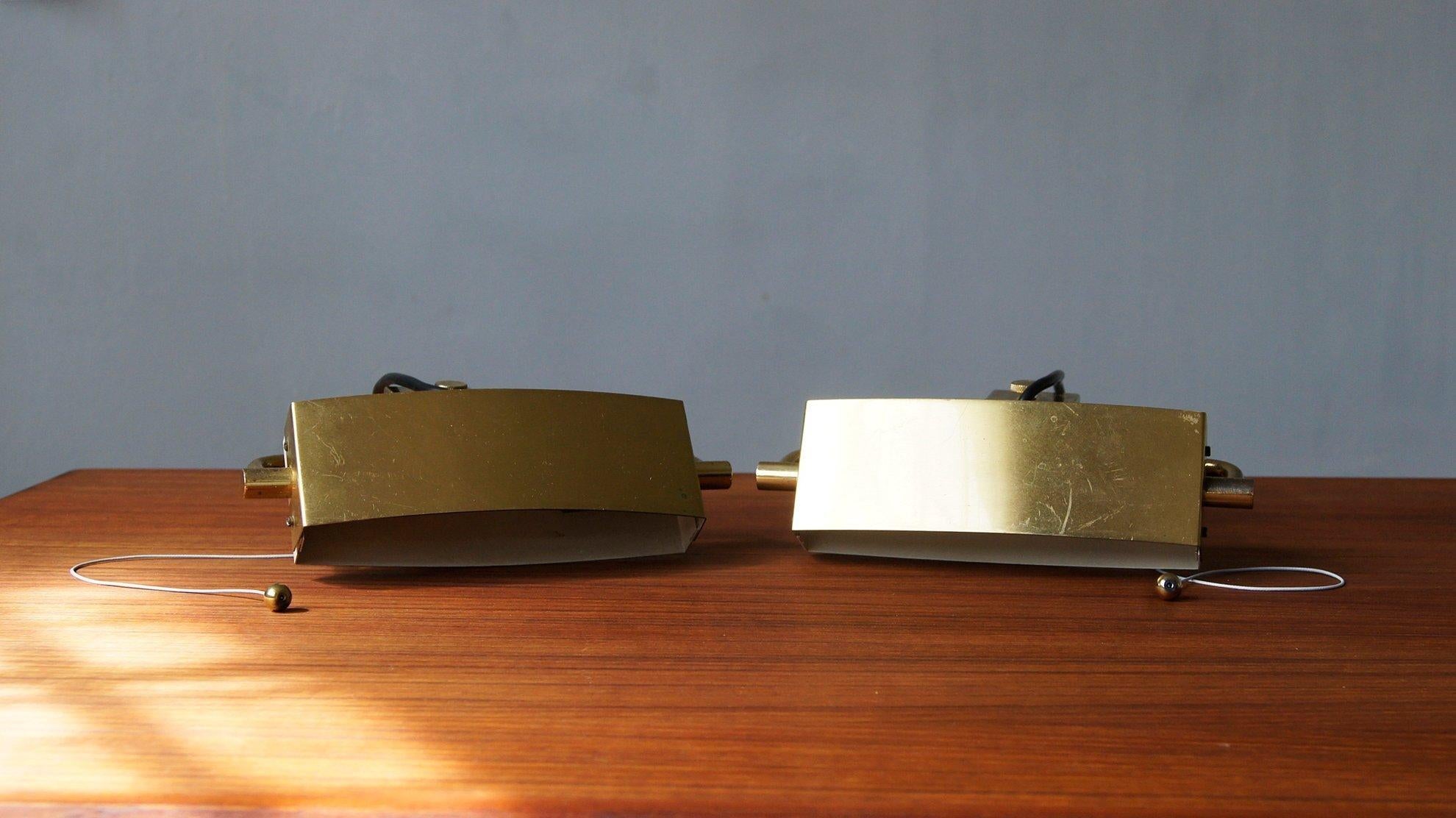Se trata de una lámpara de pared de acero y latón en acabado dorado y beige.

Pantalla giratoria ovalada alargada de latón pulido. Tornillo decorativo de latón, abrazadera ajustable. Toma de baquelita E14. Interruptor de cadena.

Sustitución de las