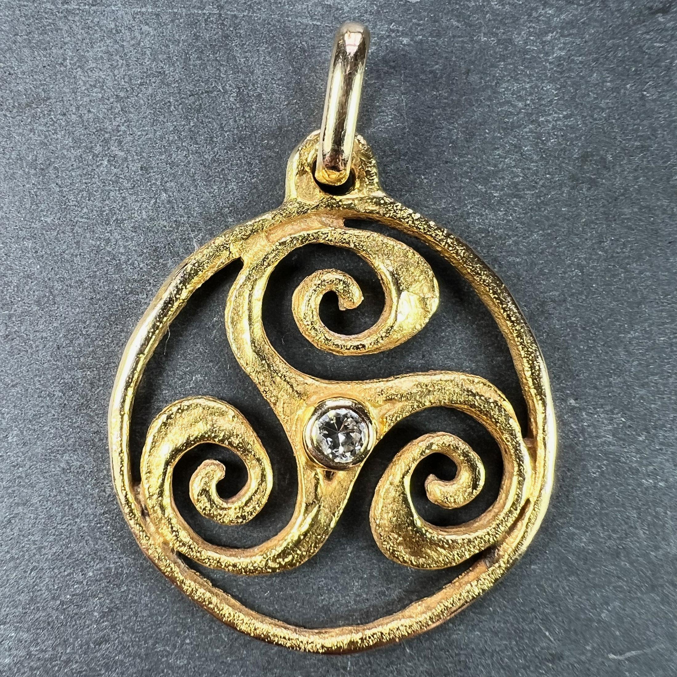 Un pendentif français en or jaune 18 carats (18K) conçu comme un triskel, un triskelion ou des triskèles (un motif ancien montrant trois bras en spirale s'étendant à partir d'un point central) serti d'un diamant rond de taille ancienne au centre