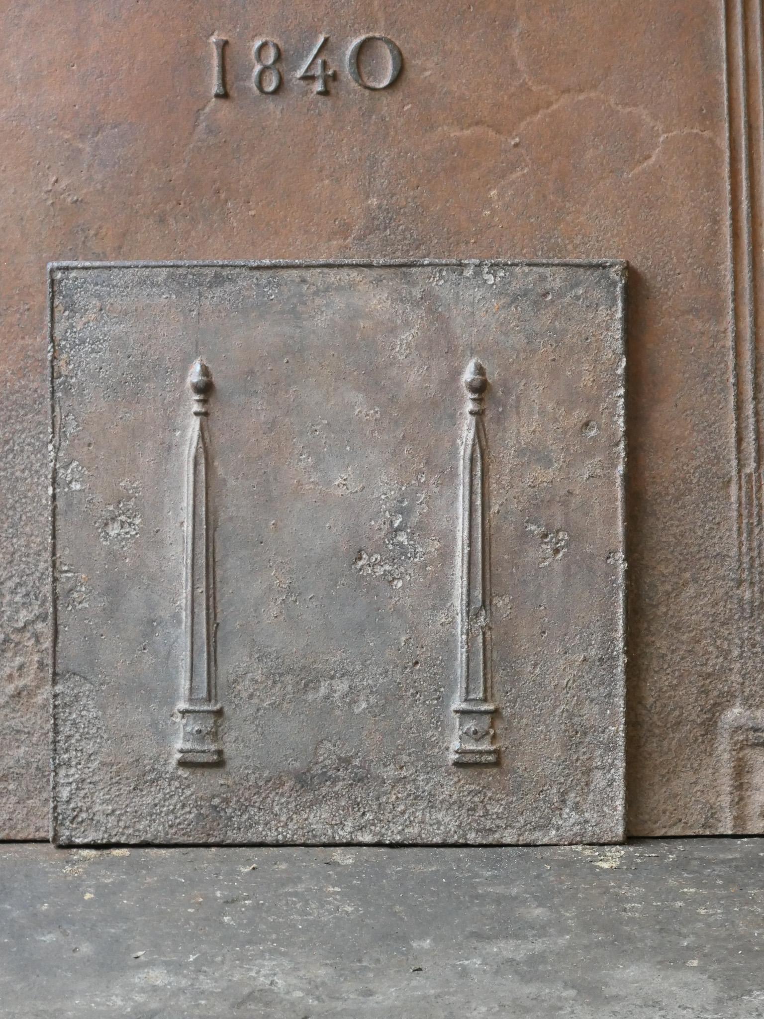 18th - 19th Century French neoclassical fireback with two pillars of freedom. The pillars symbolize the value liberty, one of the three values of the French revolution. 

The fireback is made of cast iron and has a natural brown patina. Upon