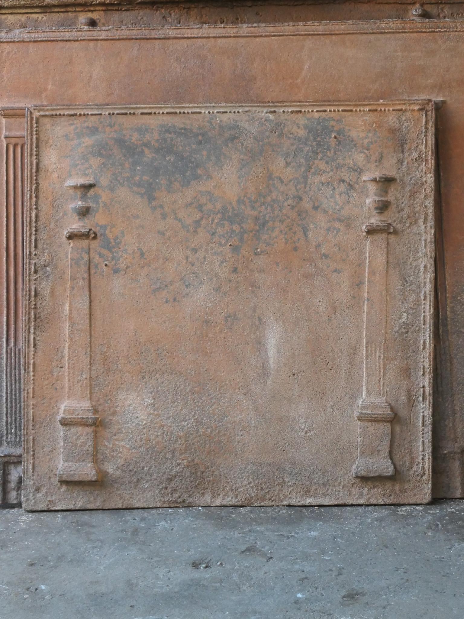 18th-19th century French neoclassical fireback with two pillars of freedom. The pillars symbolize the value liberty, one of the three values of the French revolution. 

The fireback is made of cast iron and has a natural brown patina. Upon request