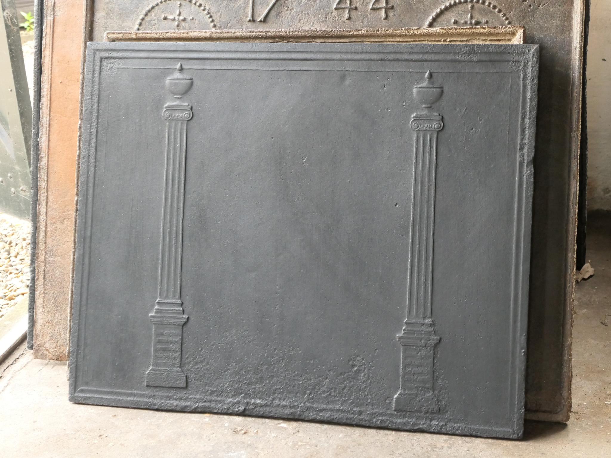 18th - 19th century French neoclassical fireback with two pillars of freedom. The pillars symbolize the value liberty, one of the three values of the French revolution.

The fireback is made of cast iron and has a black / pewter patina. It is in a