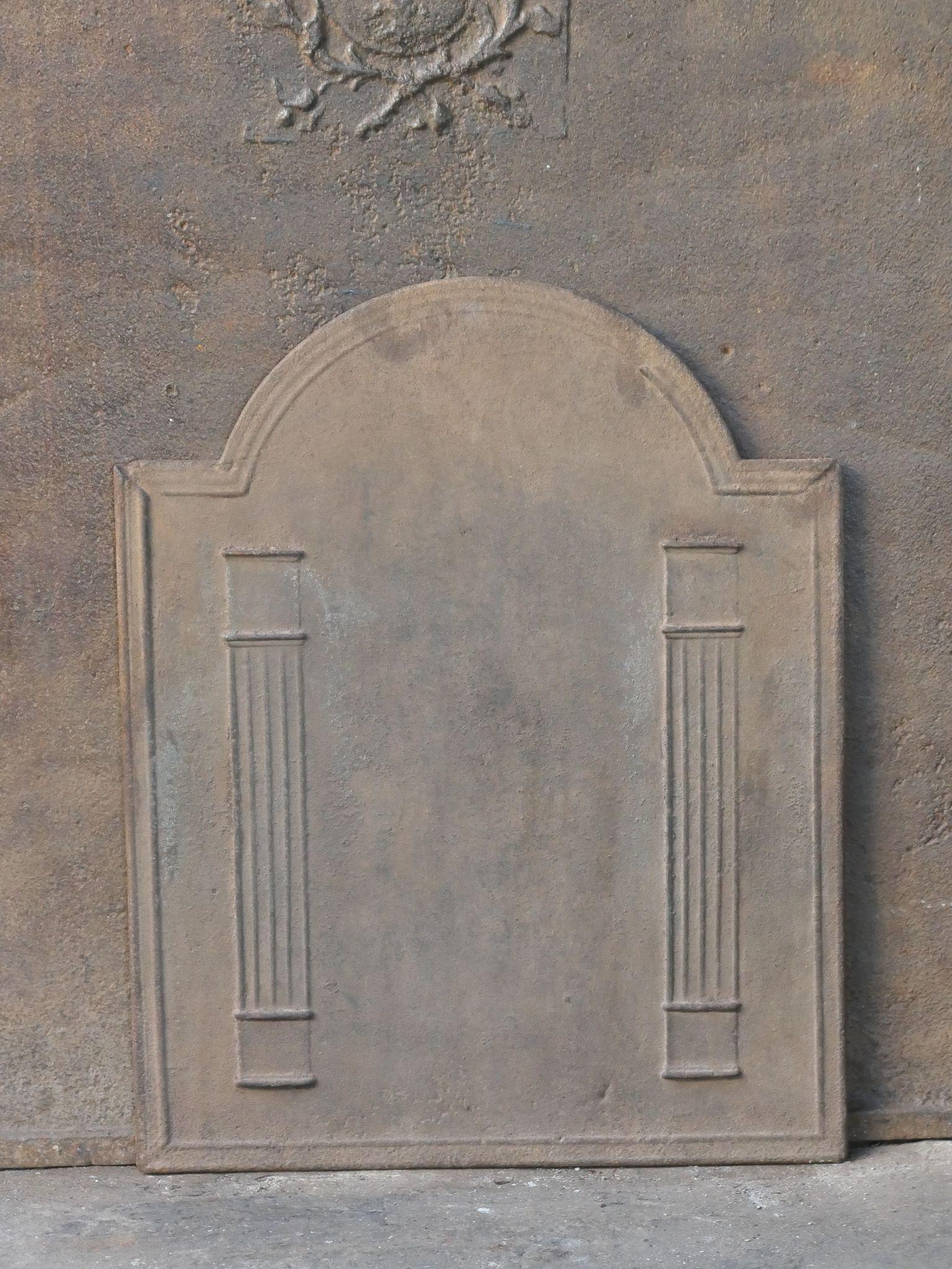 Early 19th century French Neoclassical Period fireback with two pillars of freedom. The pillars symbolize the value of liberty, one of the three values of the French Revolution.

The fireback is made of cast iron and has a natural brown patina. Upon