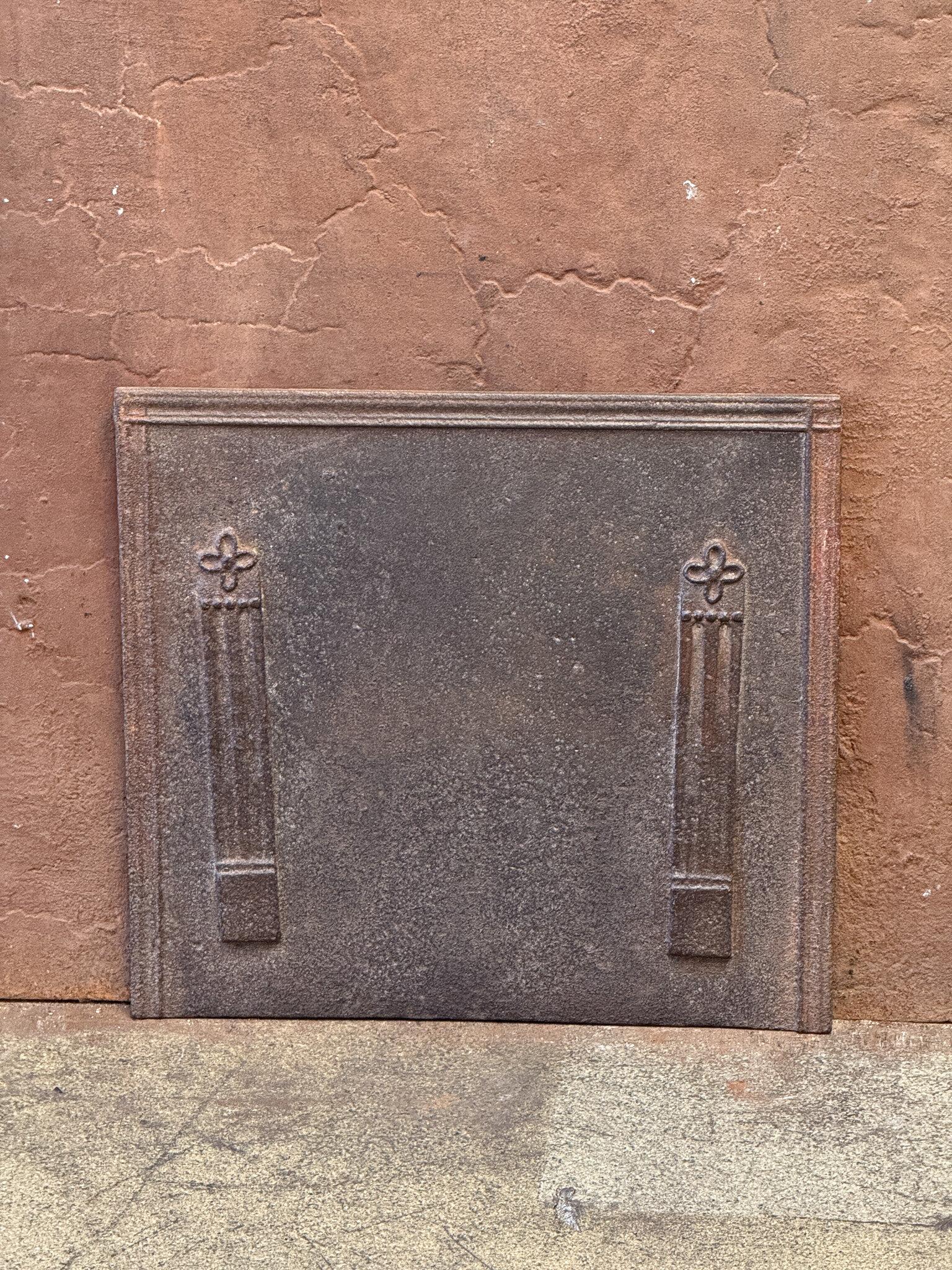 18th - 19th century French neoclassical Period fireback with two pillars of freedom. The pillars symbolize the value of liberty, one of the three values of the French Revolution. 

The fireback is made of cast iron and has a natural brown patina.