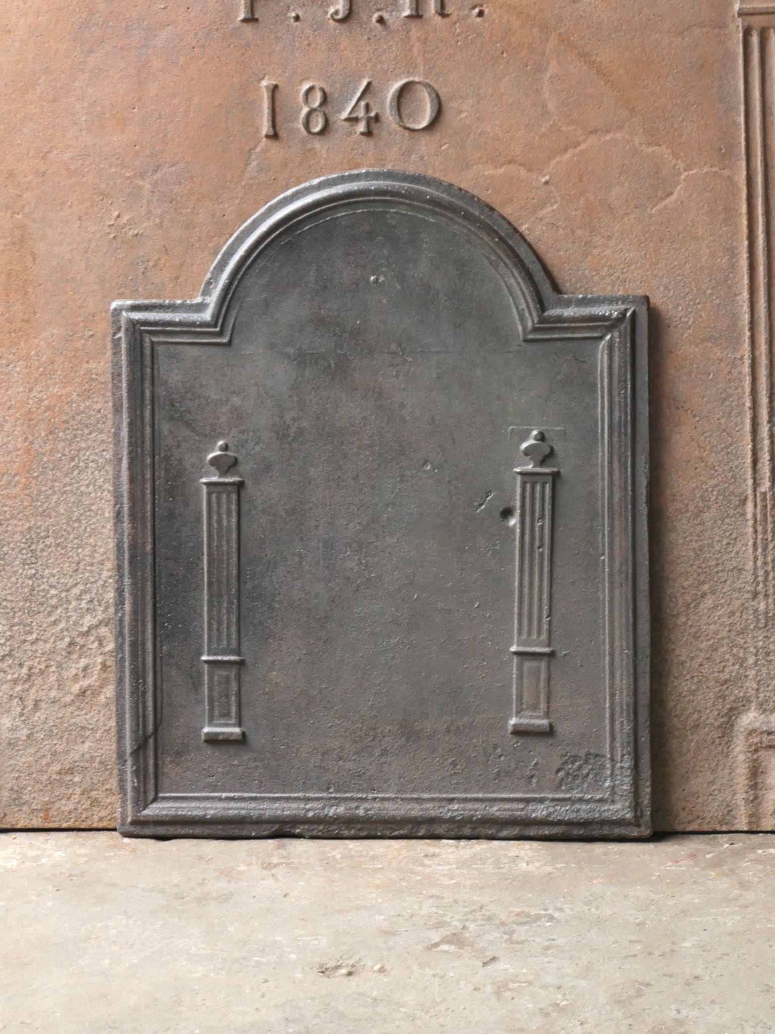Plaque de cheminée néoclassique française du XIXe siècle avec deux piliers de la liberté. Les piliers symbolisent la valeur de la liberté, l'une des trois valeurs de la Révolution française. 

La plaque de cheminée est en fonte et a une patine brune