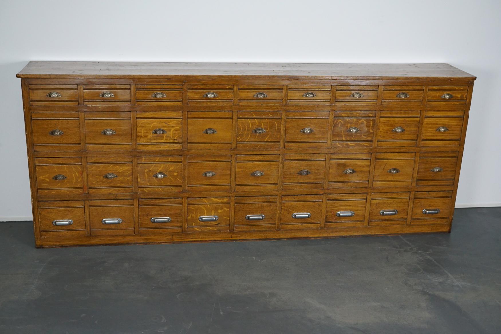 This cabinet was designed and made in the early 20th century. It features two sizes of drawers with amazing pulls. The interior dimensions of the drawers are: small 29 x 19.5 x 8.5 cm and large 29 x 19.5 x 18 cm. The cabinet is made from pine but