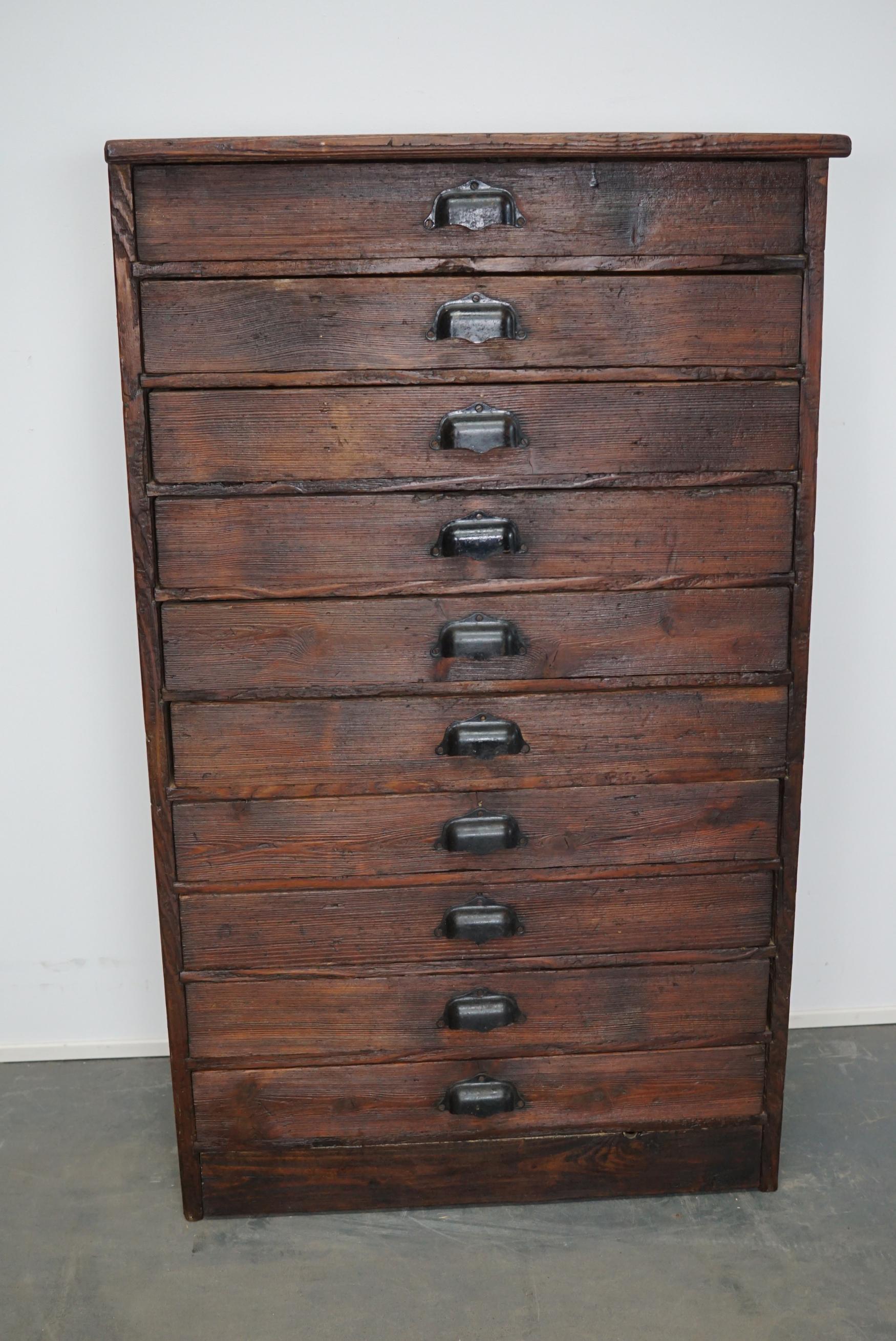 This workshop cabinet was made from pine in France circa mid-20th century. It features 10 drawers with black metal cup handles. Some of the drawers have dividers. The interior dimensions of the drawers are: DWH 29.5 x 56.5 x 6.7 cm.