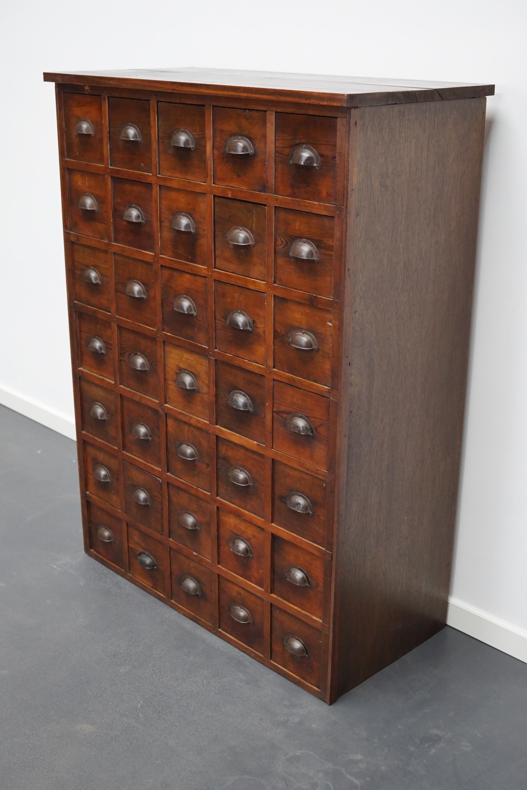 This workshop cabinet was made from pine in France circa mid-20th century. It features 35 drawers with metal cup handles. The interior dimensions of the drawers are: DWH 35.5 x 12.5 x 13.5 cm.