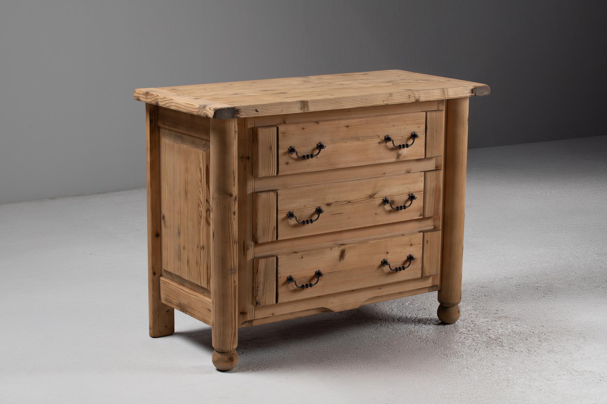 Robust in presence yet restrained in ornament, this French pine commode from the 1940s is a study in sculptural utility. With softly rounded edges and turned ball feet, it embodies the rustic modernism of postwar alpine interiors—where craftsmanship