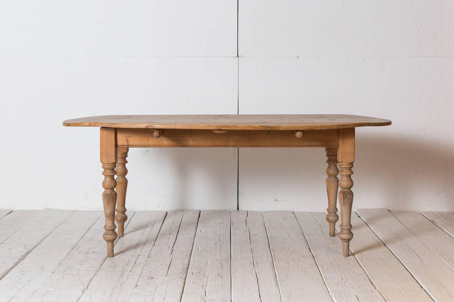 French pine drop-leaf table with spindle legs, table extends to be an oval dining table. Table measures 44