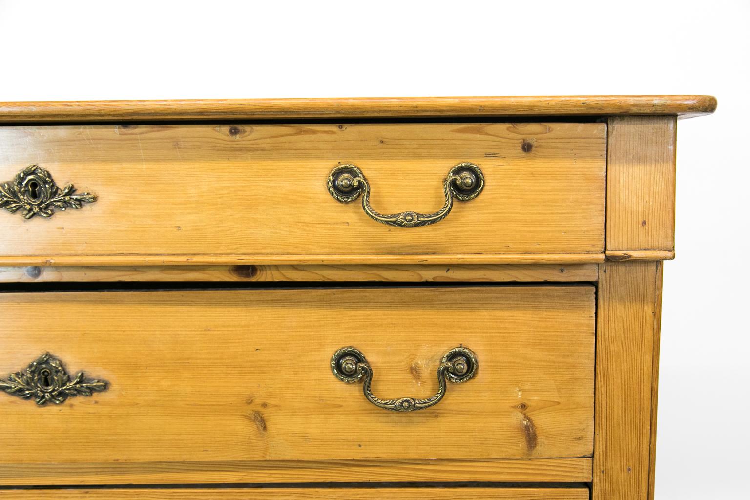 French pine four-drawer chest has the original working lock and key, and the top edge has bull nose shaping. The top drawer breaks out slightly over the lower three drawers. The base is a solid 4 1/2” plinth.