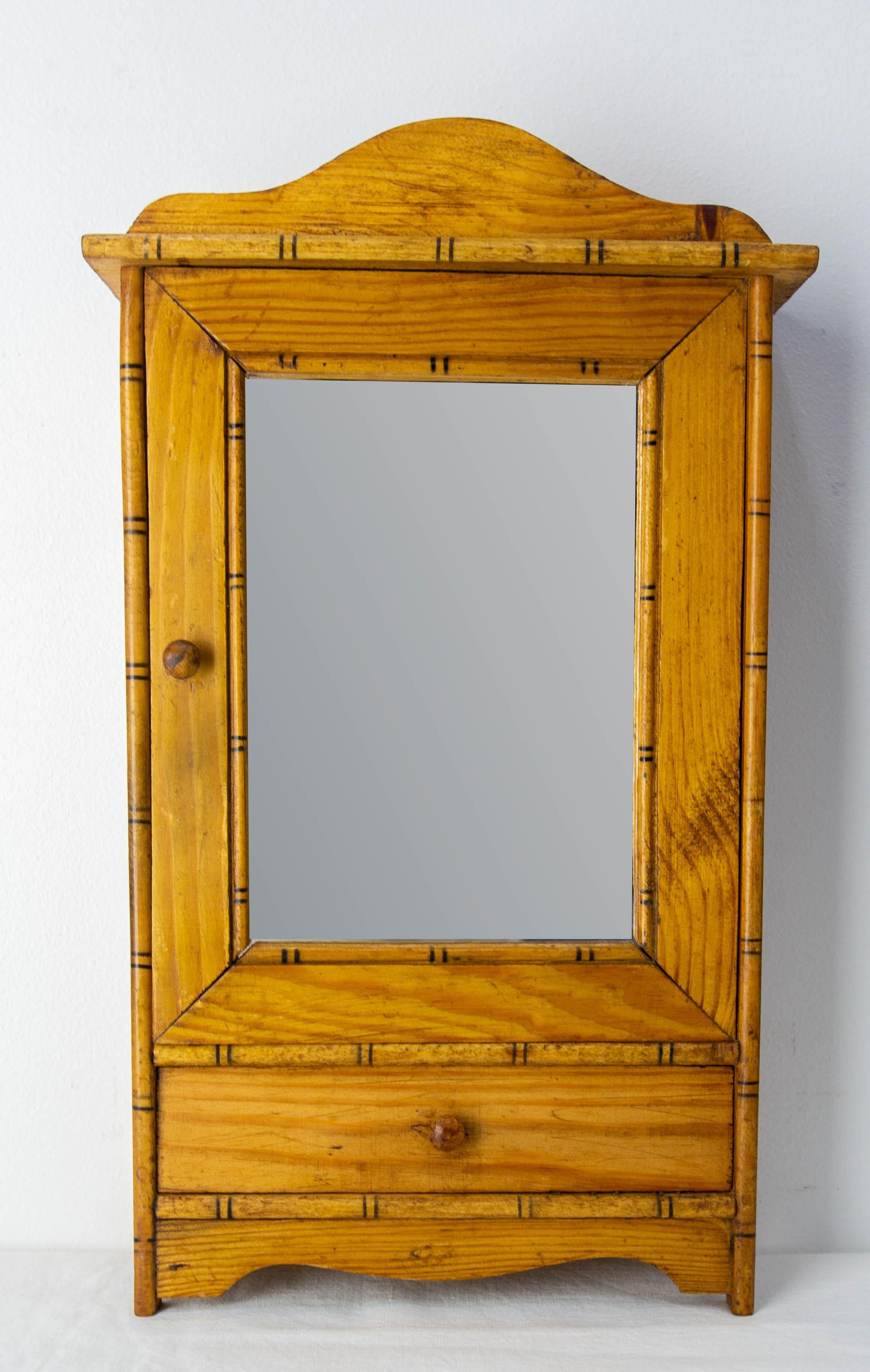 Petite armoire de poupée en pin avec un miroir et un tiroir.
La porte, le miroir et le tiroir sont entourés de cadres en bambou.

Etat ancien, mais peu de traces d'âge et d'utilisation.

Expédition :
10 / 25  / 41 cm 1 kg