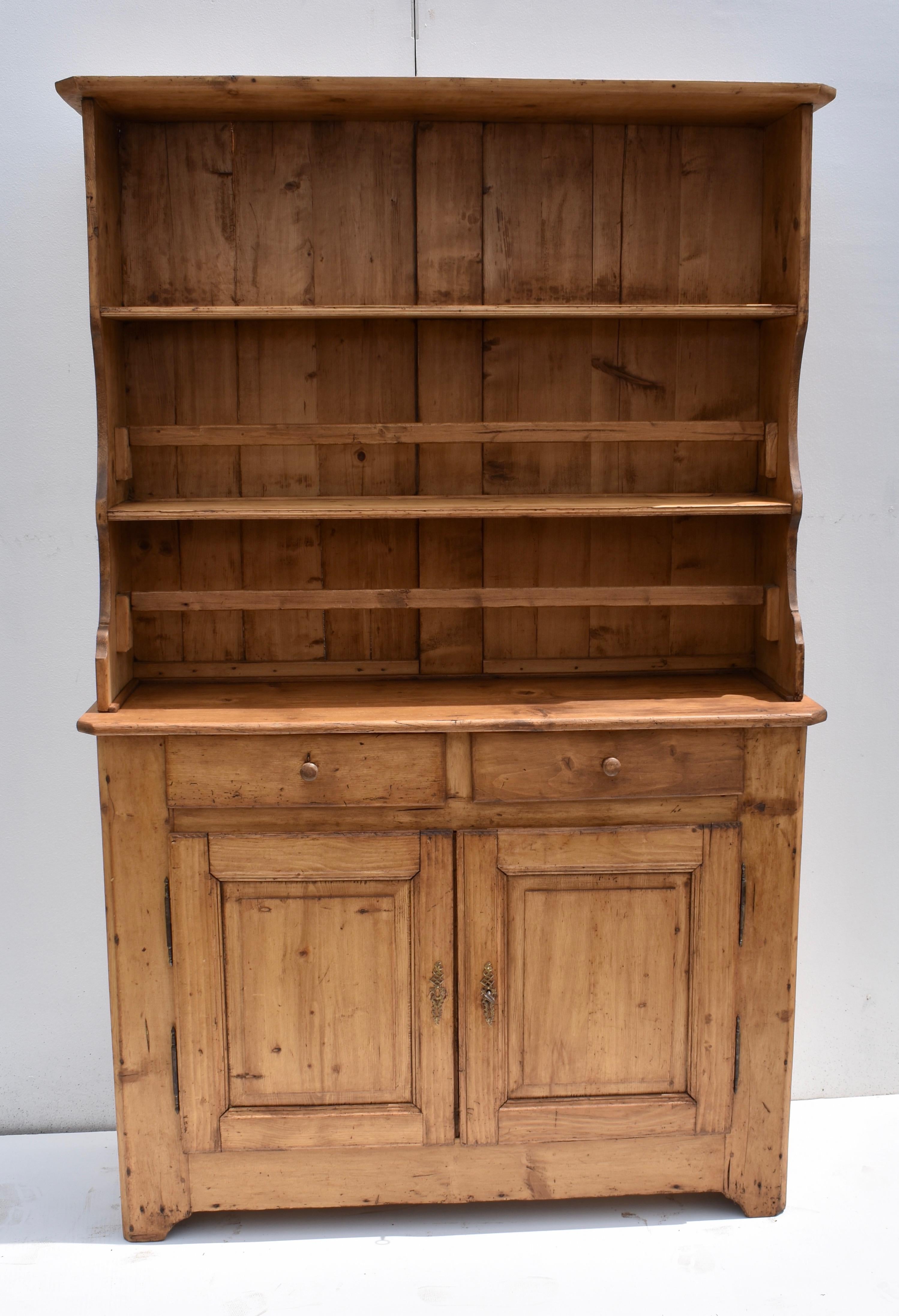 It is rare to find a complete French pine vaissellier, so many of the racks of shelves and sideboard bases became separated over the years. Here is a nice example that this dealer first sold over thirty years ago. The upper section has two shelves