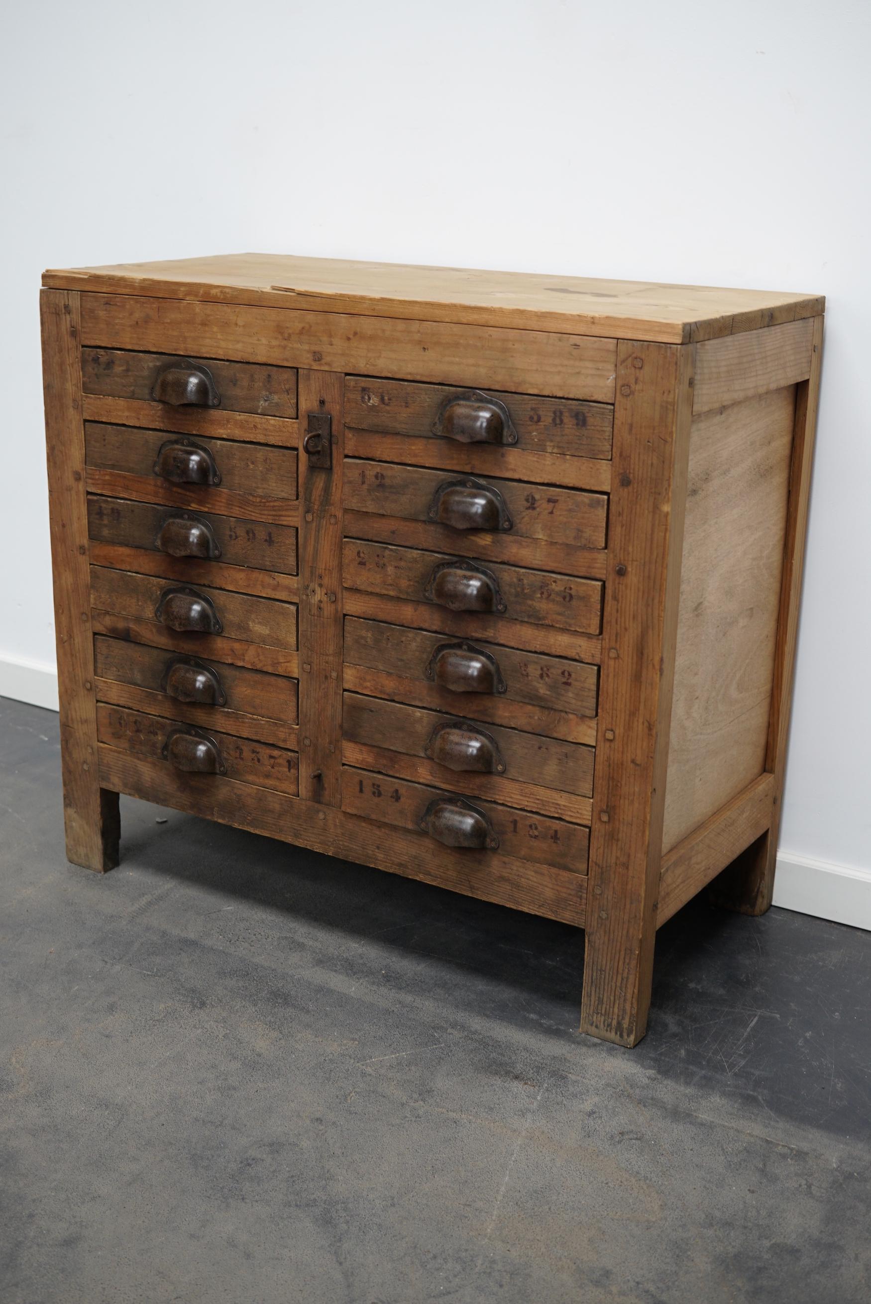 This workshop cabinet was made from pine in France circa mid to early 20th century. It features 12 drawers with metal cup handles. All the drawers have dividers. The interior dimensions of the drawers are: DWH 32 x 25 x 4 cm.
