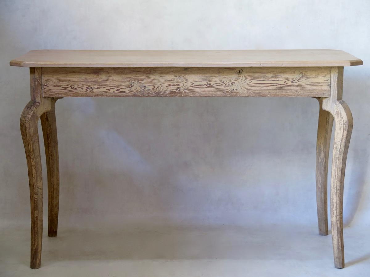 Elegant, simple painted pinewood table of nice proportions. The top has canted corners, and is raised on cabriole legs.