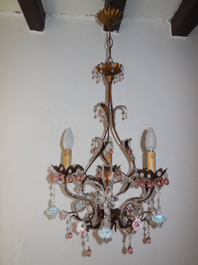 Housing three lights, will be rewired with certified UL US sockets for the USA and certified sockets for other countries and ready to hang. Tole body with beaded leaves and bottom. Adorning rare pink drops and beads on top throughout. Also,