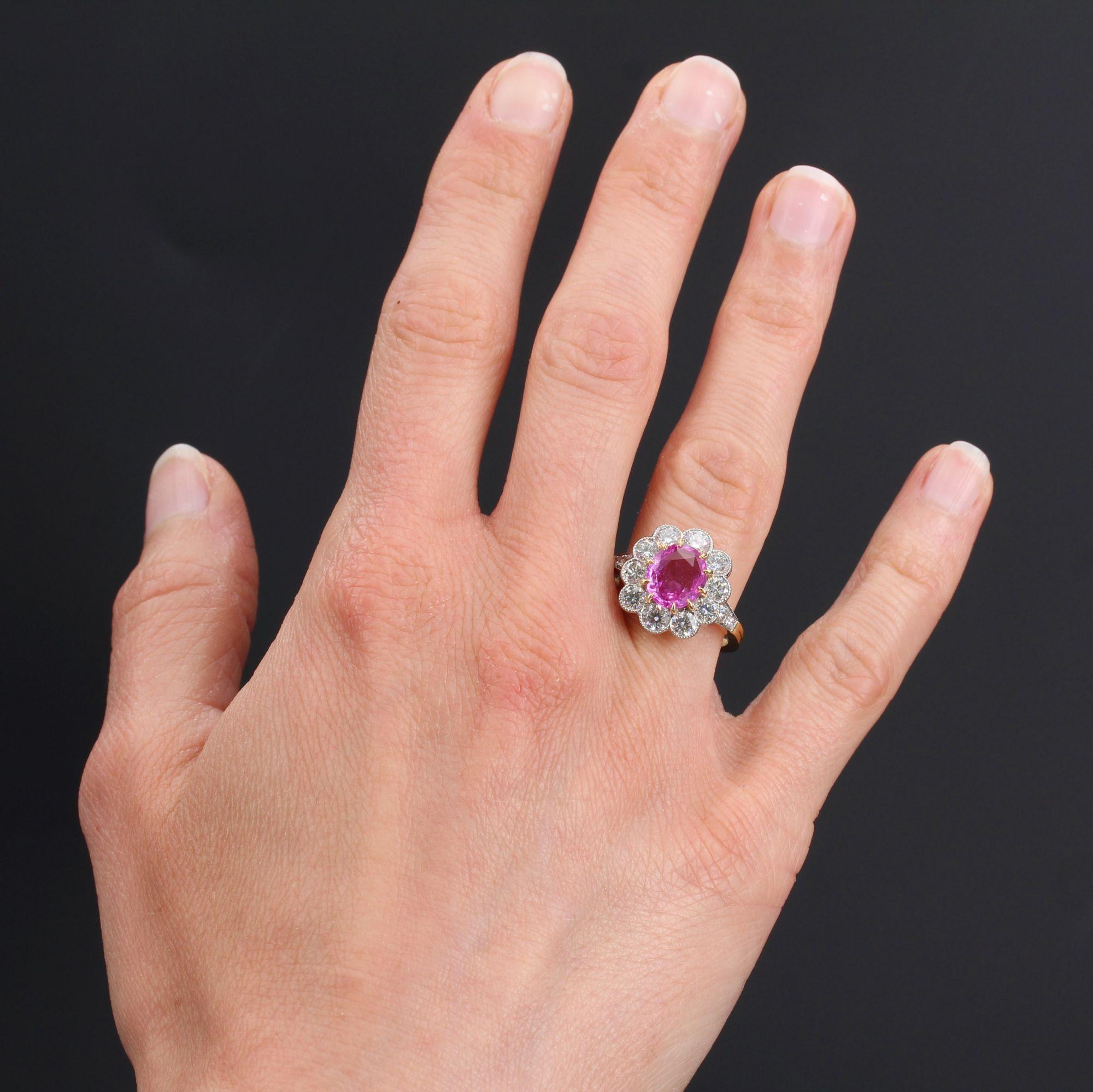 Ring in 18 karat yellow gold, eagle head hallmark and platinum, dog head hallmark.
This splendid daisy ring is set with claws of an oval pink sapphire surrounded by 10 modern brilliant- cut diamonds, in millegrain setting. On either side of the head