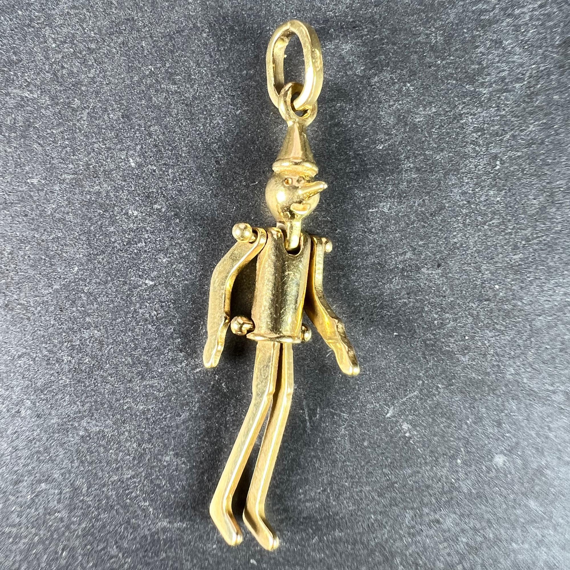 Ciondolo charme articolato francese in oro giallo 18 carati (18K) disegnato come una bambola di Pinocchio con il naso allungato. Timbro a testa d'aquila per l'oro a 18 carati e la manifattura francese, marchio di fabbrica parzialmente sconosciuto e