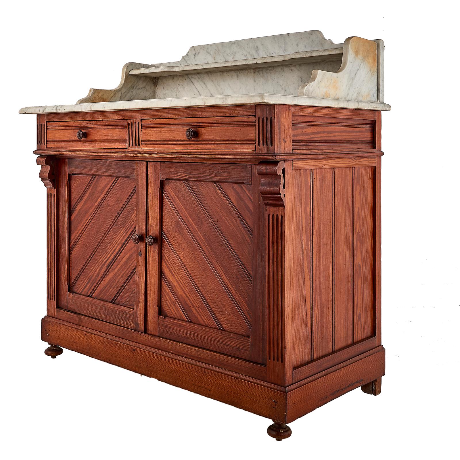 A French washstand in pitch pine, the two upper drawers above two-door cabinet, the carrara marble top with shelf at back, circa 1890.

Measures: 39.5? wide x 22? deep x 31? tall (41? tall at back).

