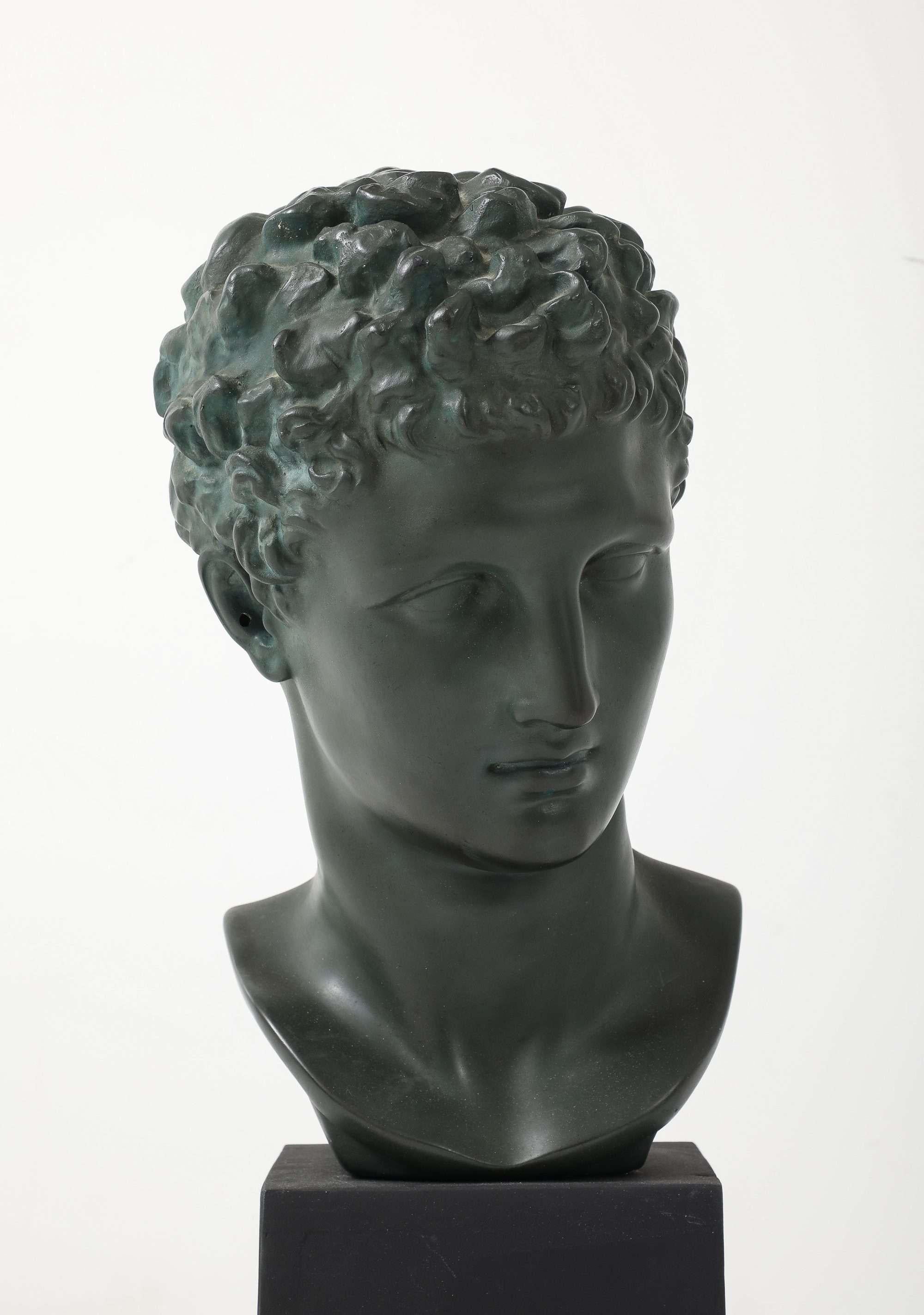 A finely cast plaster bust depicting Hermès (Mercury), modeled after a 4th-century BC Greek original.

The head is crisply detailed—tight curls, subtly parted lips, and a confident downward gaze. The clean block base lets the classical form read as