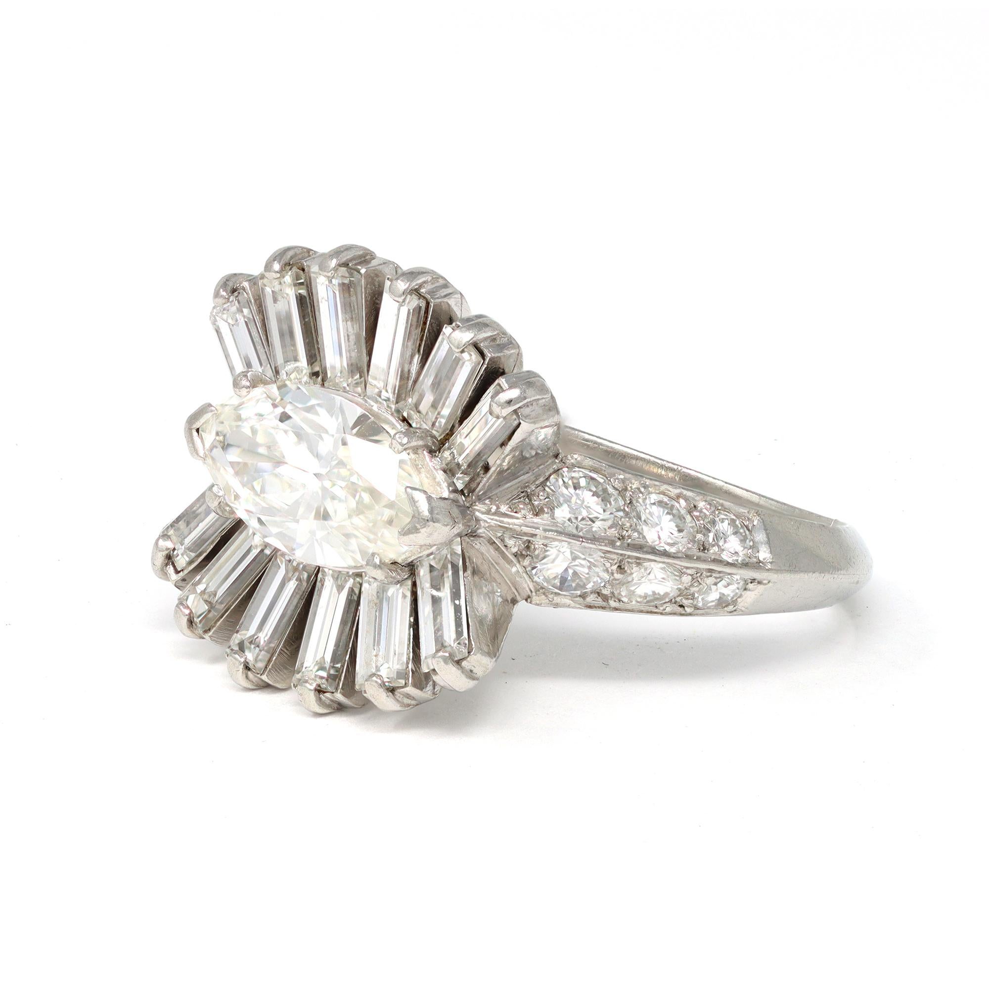 The handmade platinum cocktail/engagement ring was made in France circa 1950. It features an old marquise diamond in its center stone weighing approximately 1.10 carat G color VS clarity. The solitaire marquise is surrounded by a basket of baguette