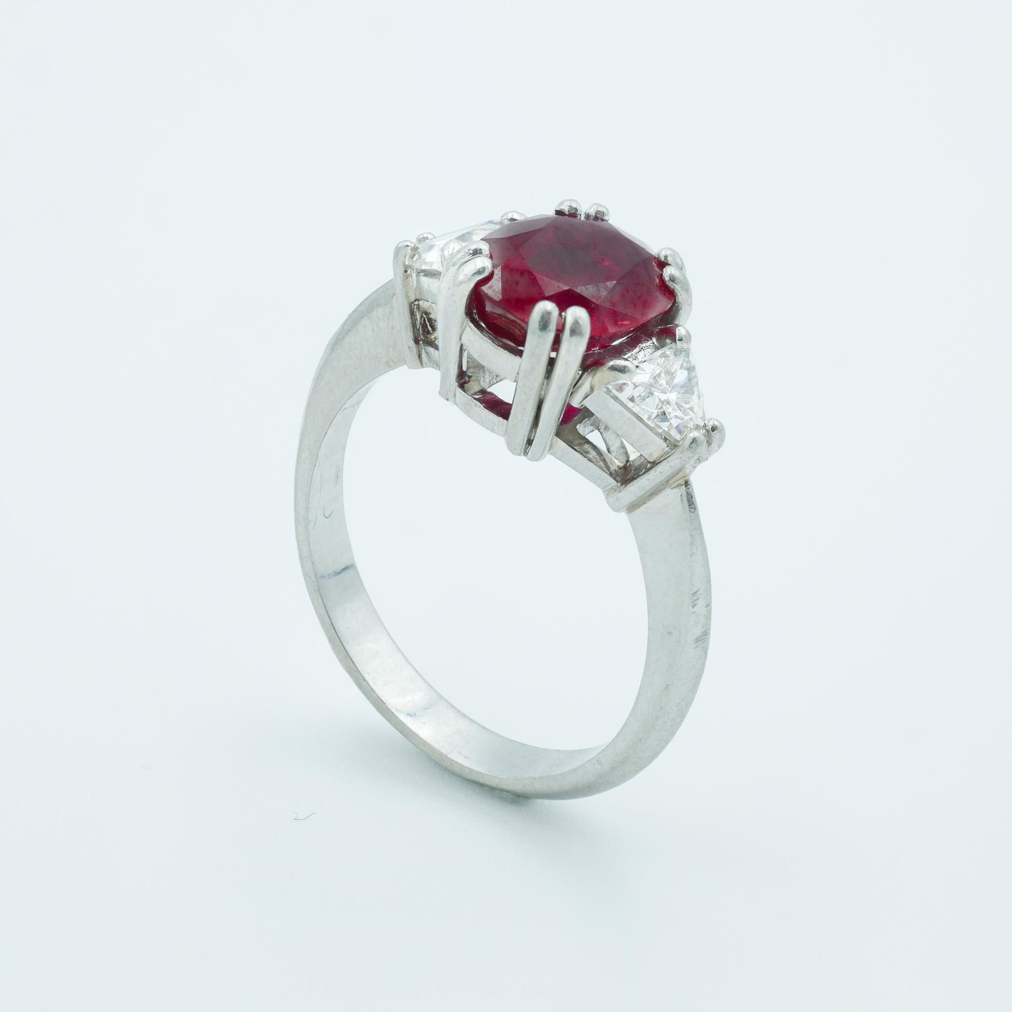 This is a striking French platinum-mounted ring that boasts a luxurious 1.3-carat heated Burma ruby. The ruby exudes a deep, vivid red hue, a hallmark of the finest Burmese rubies, known for their exceptional color and clarity. The ruby is round