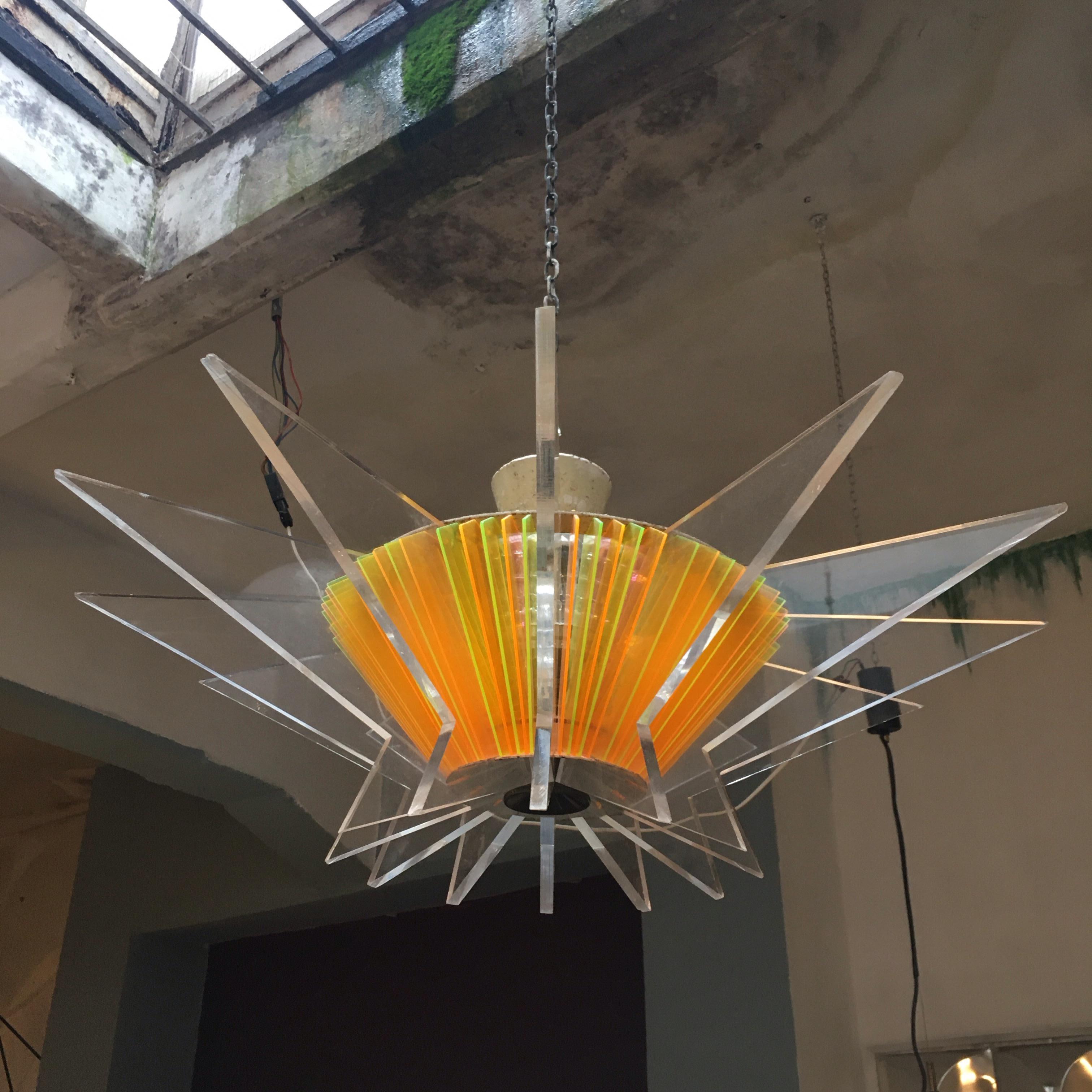 French geometric ceiling lamp from the 1980s, made of plexiglass of various colors, with a brass detail in the center and three metal lampholders with bayonet connection, good general conditions.