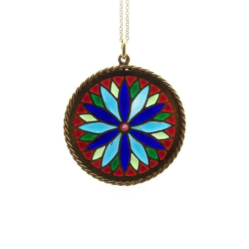 When held up to the light, this beautiful 18k gold plique-à-jour pendant glows like a stained glass window. To create this effect, five colors of transparent enamel are suspended between 18k gold backless cells to allow light to shine through and
