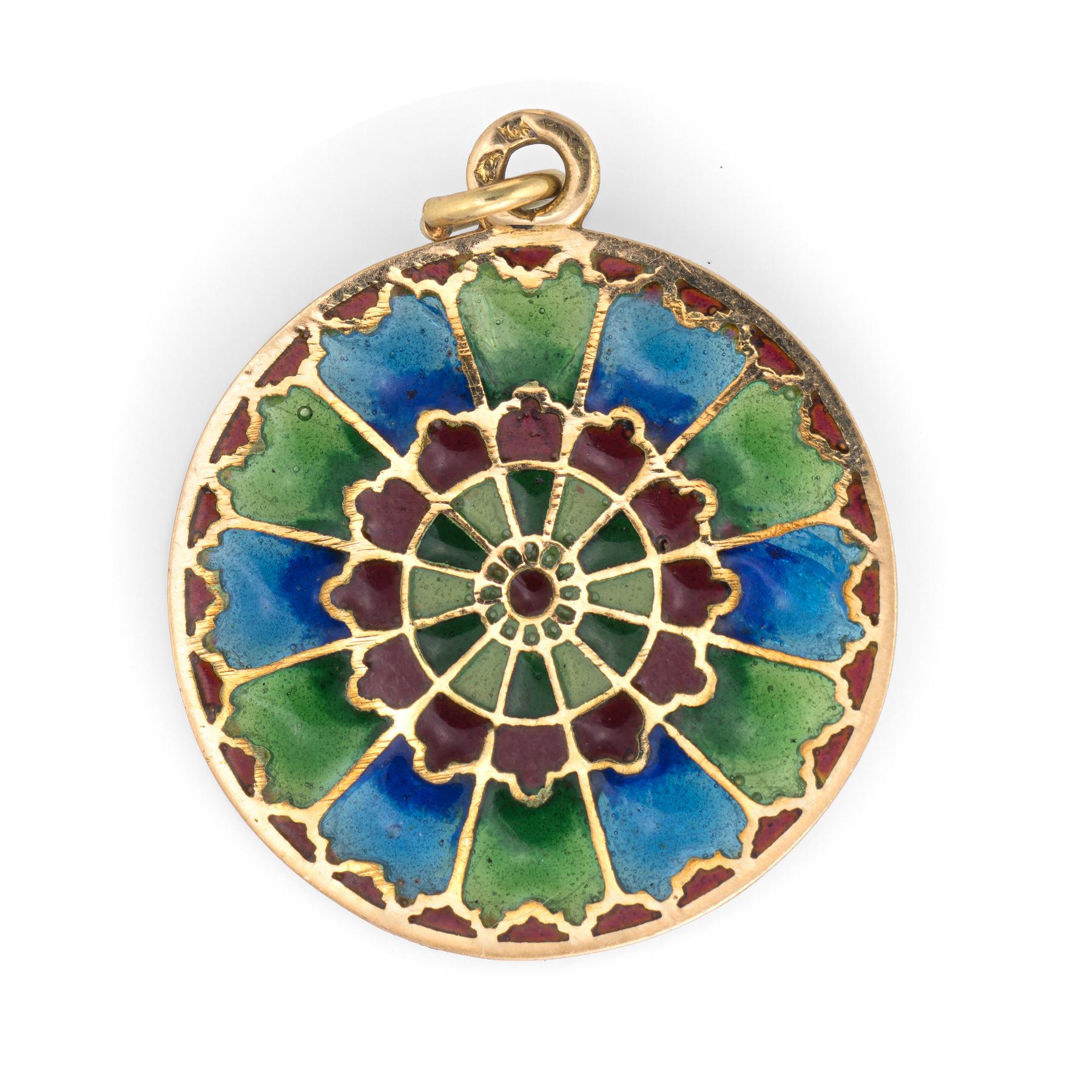 Finely detailed French plique a jour pendant (circa 1920s to 1930s), crafted in 18 karat yellow gold. 

A kaleidoscope of colors adorn the pendant in shades of red, blue and green.
 
Plique a jour is a French term for 'letting in daylight'. The