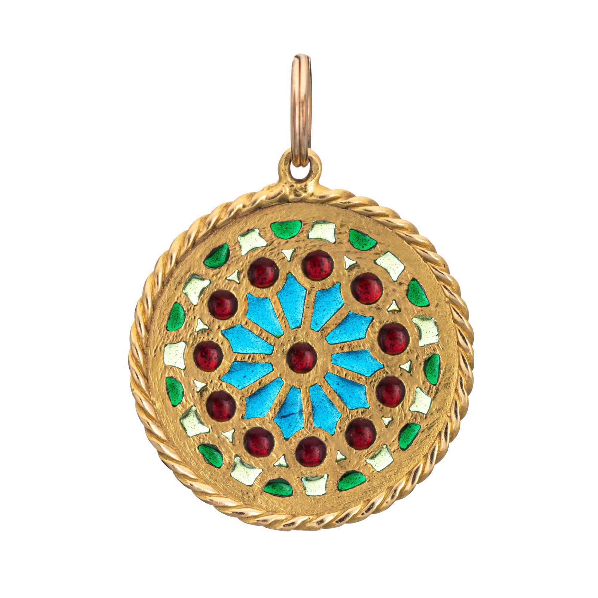 Finely detailed French plique a jour pendant (circa 1920s to 1930s), crafted in 18 karat yellow gold.

A kaleidoscope of colors adorn the pendant in shades of red, blue and green.
 
Plique a jour is a French term for 'letting in daylight'. The
