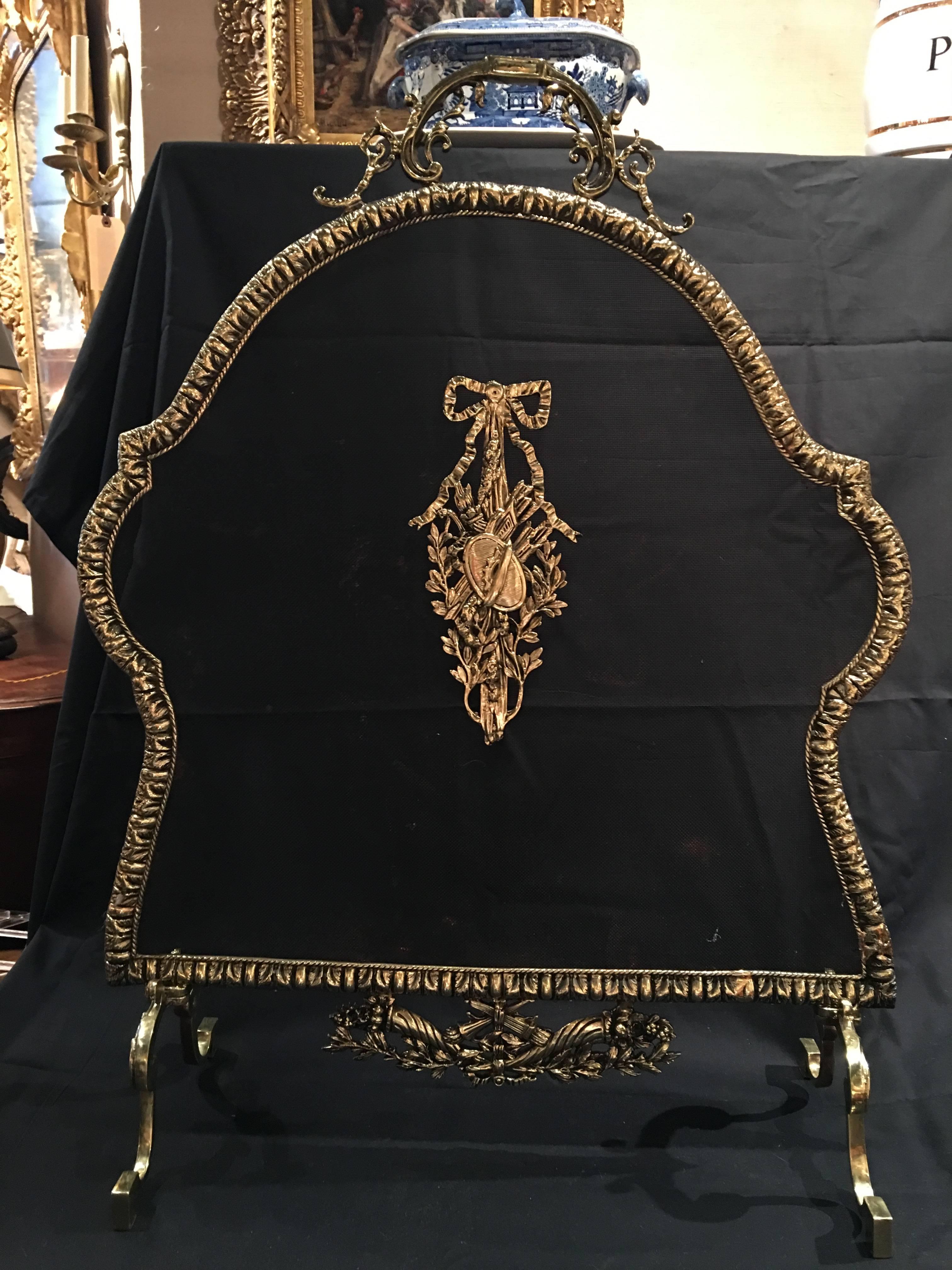 French polished brass fireplace screen with decorative bow, 19th century.