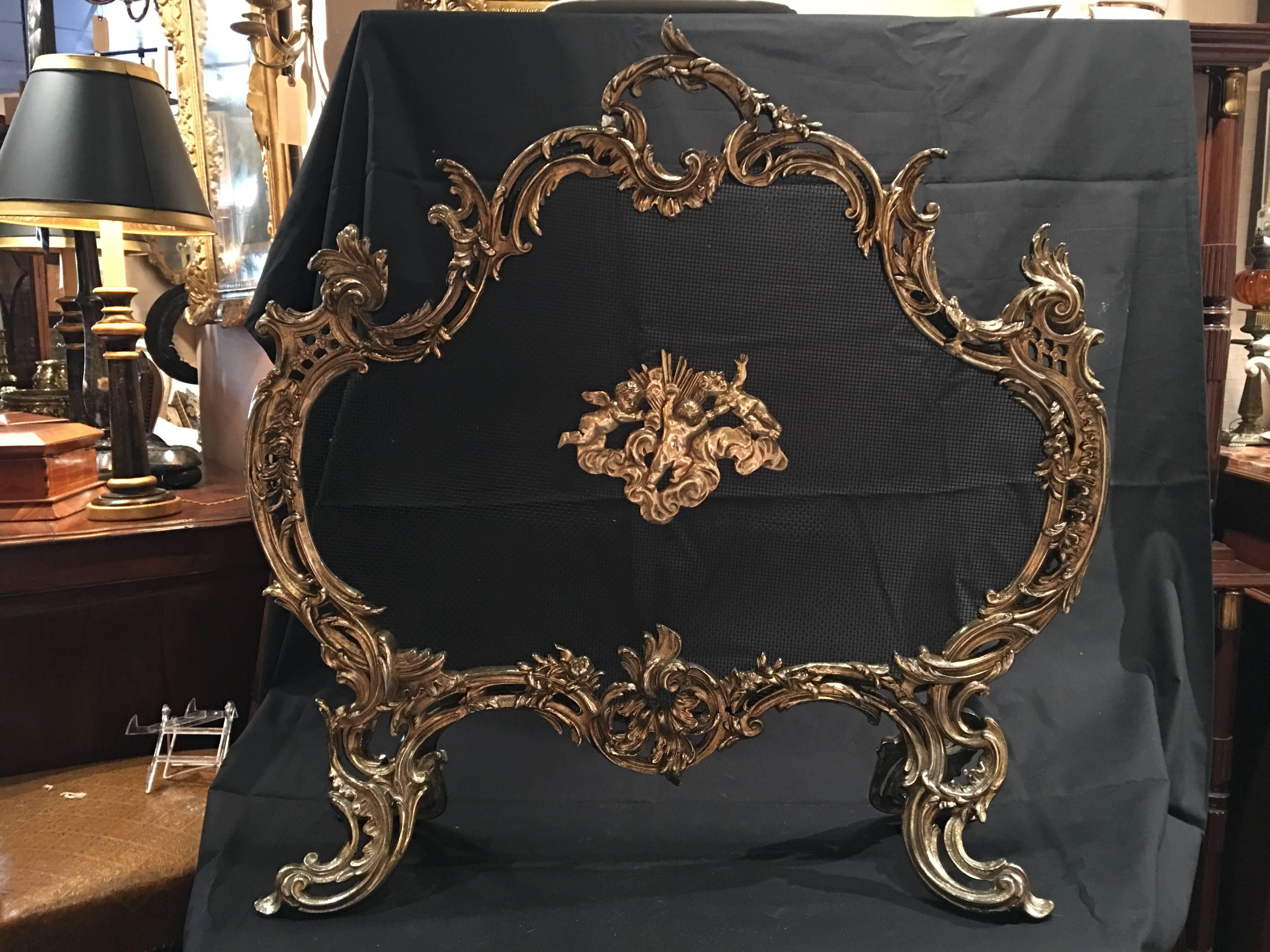 French polished brass fireplace screen with decorative cherubs, 19th century.