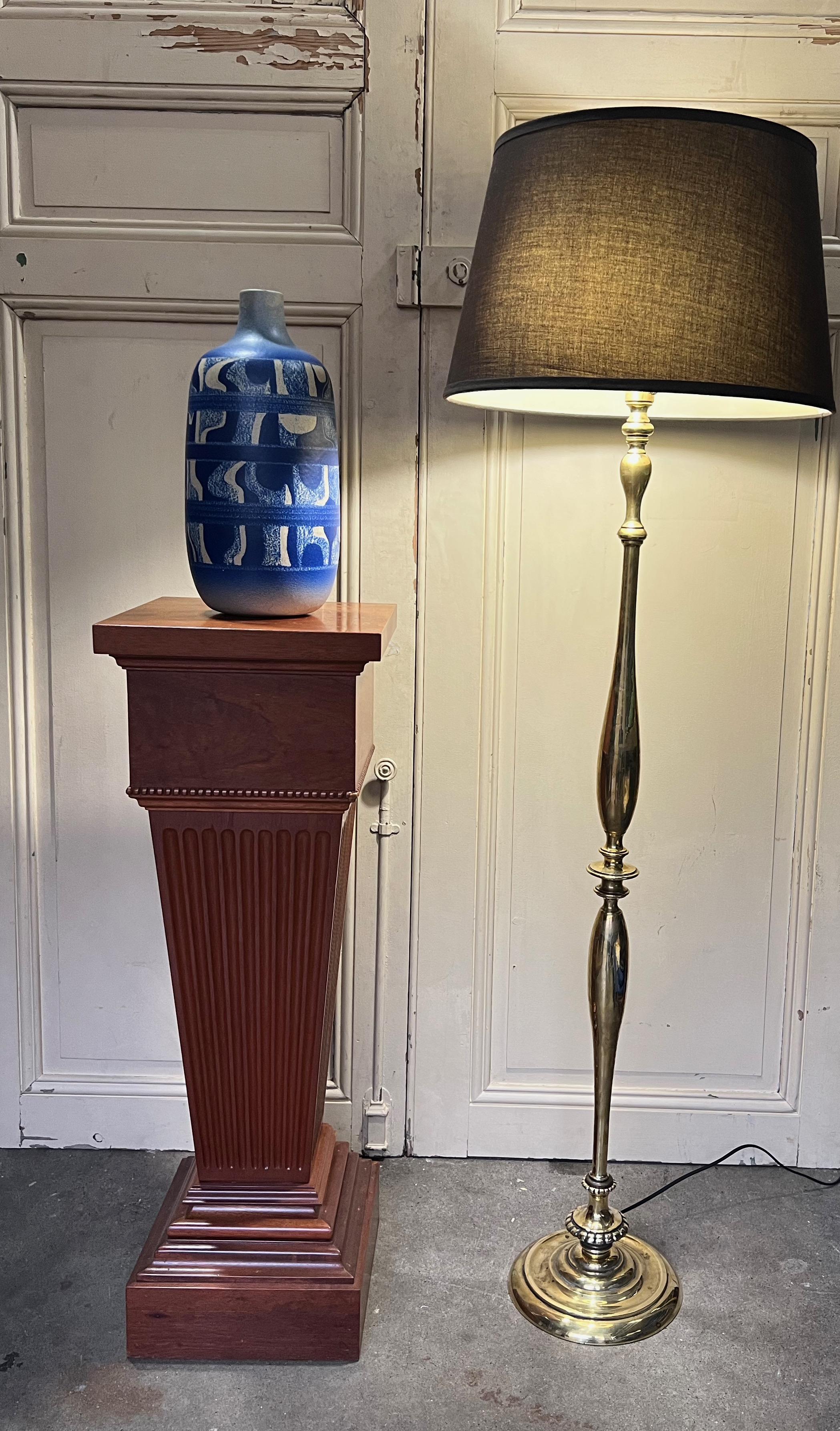 Ce magnifique lampadaire français en laiton poli des années 1940 est un ajout élégant à toute maison. La base ronde en fonte fournit un support solide à la lampe, tandis que deux pièces centrales tournées en forme de goutte d'eau encadrent trois