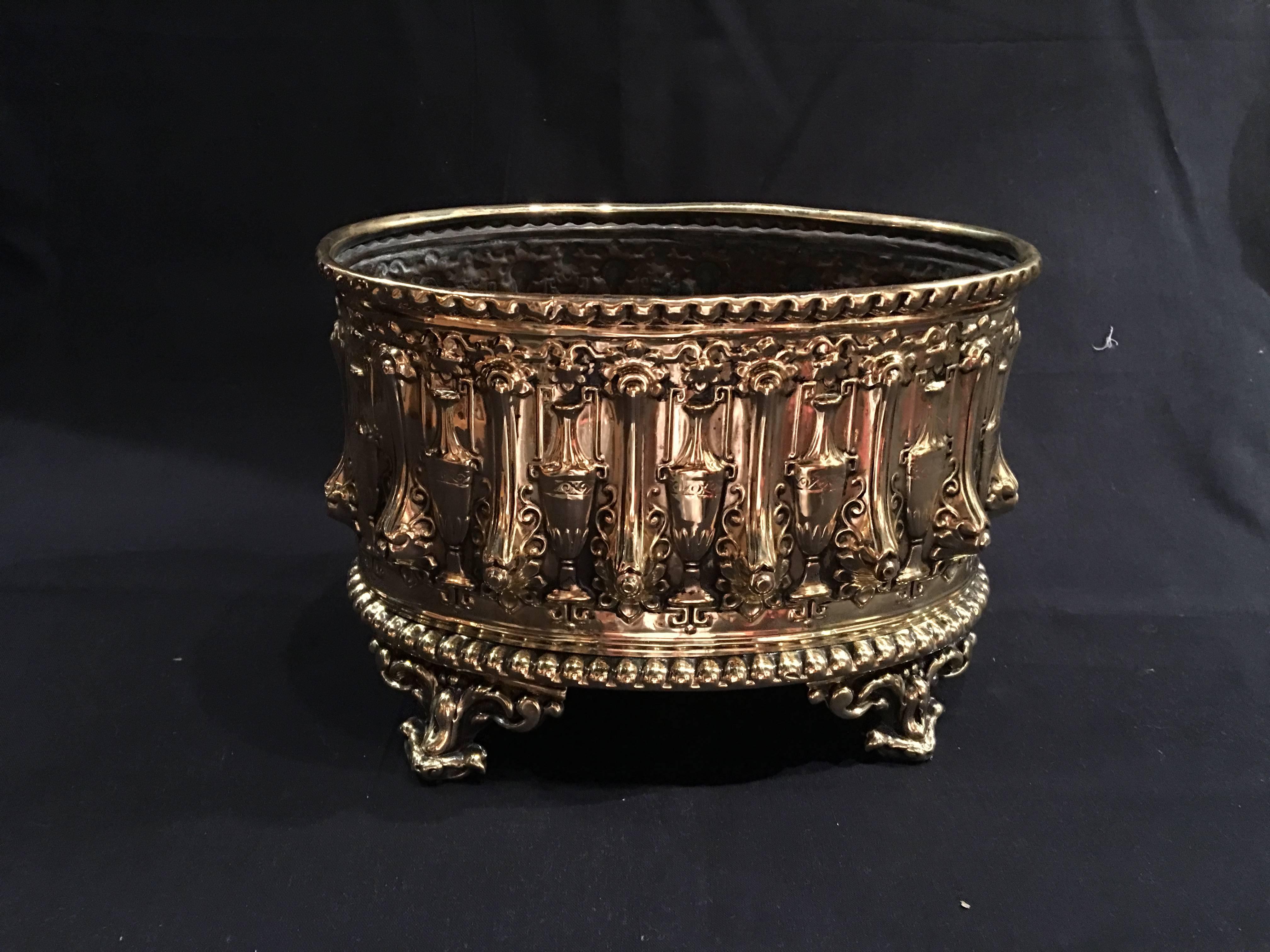 French polished brass jardiniere or container with liner on feet, 19th century.