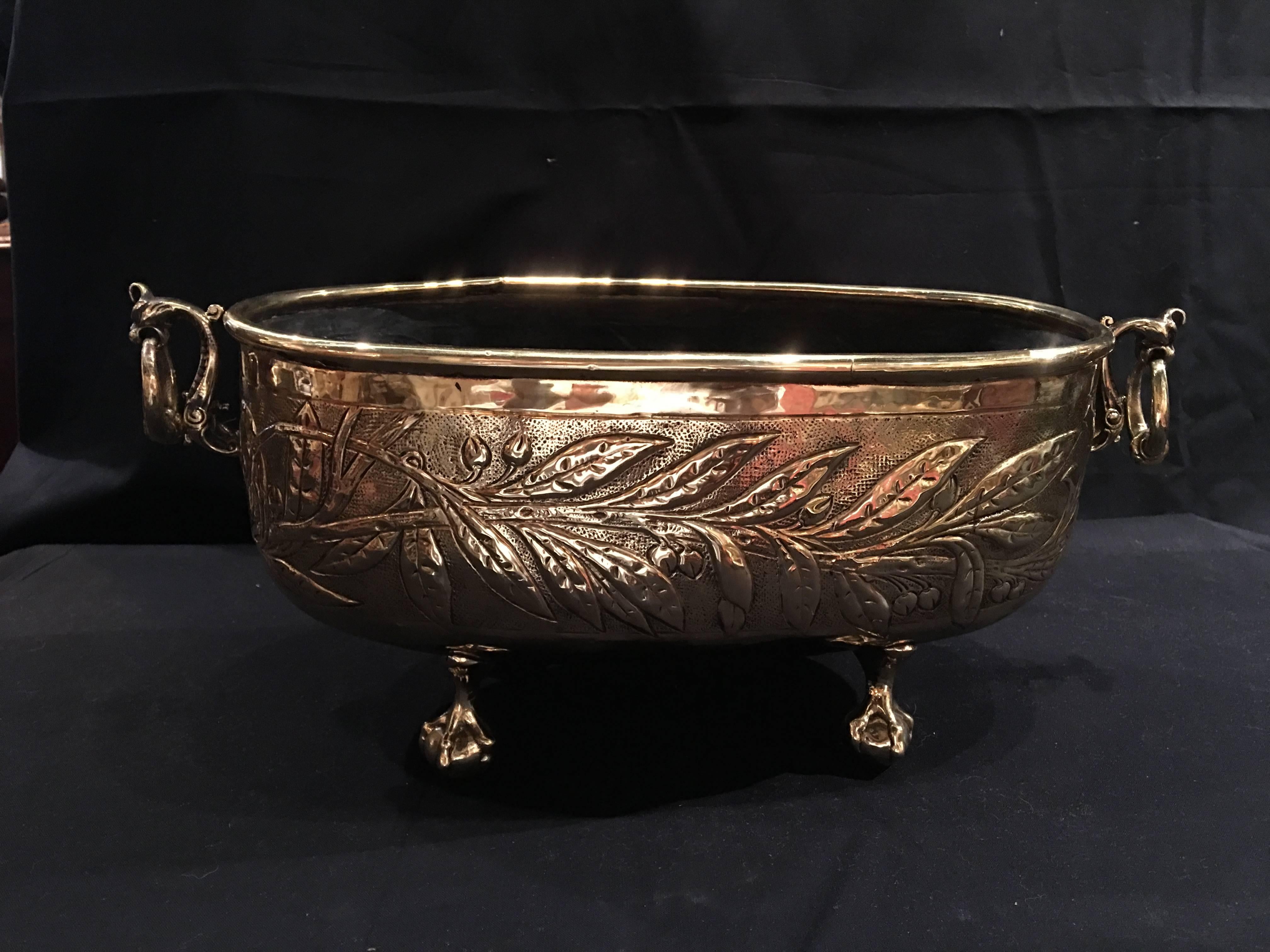 French polished brass oval jardinière or planter, 19th century. Ball and claw feet.