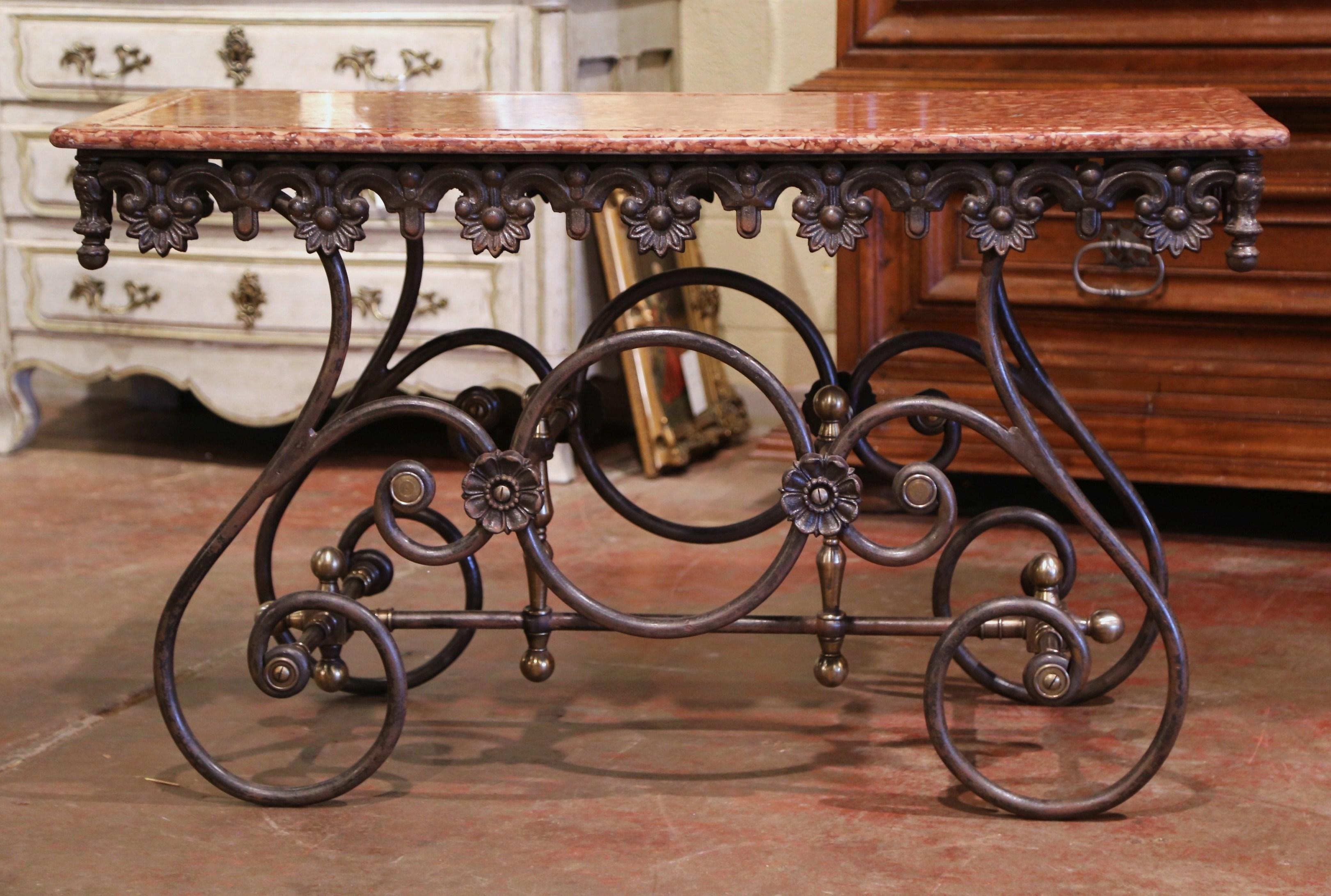 Crafted in France circa 2000, this long and narrow butcher table (or pastry table) would add the ideal amount of surface space to any kitchen. The table has a polished iron finish and features a scalloped apron with intricate metal work and