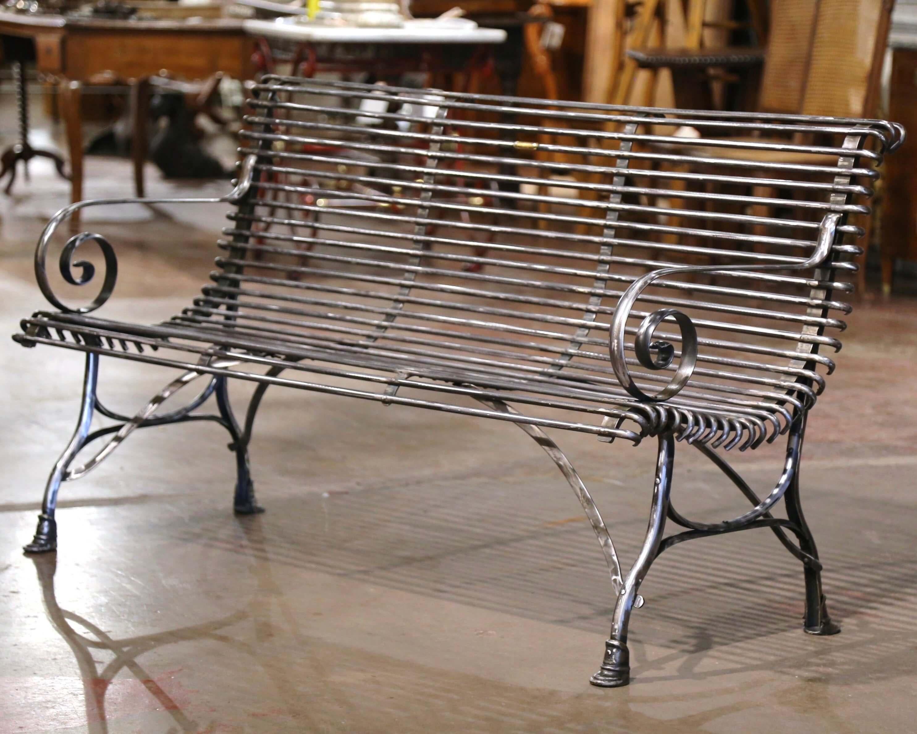 Ajoutez une assise supplémentaire à un espace extérieur couvert avec ce banc en fer forgé de France, à la fois élégant et simple. Cette banquette à trois places, au fini poli argenté, présente des lignes gracieuses, de beaux accoudoirs à volutes, un