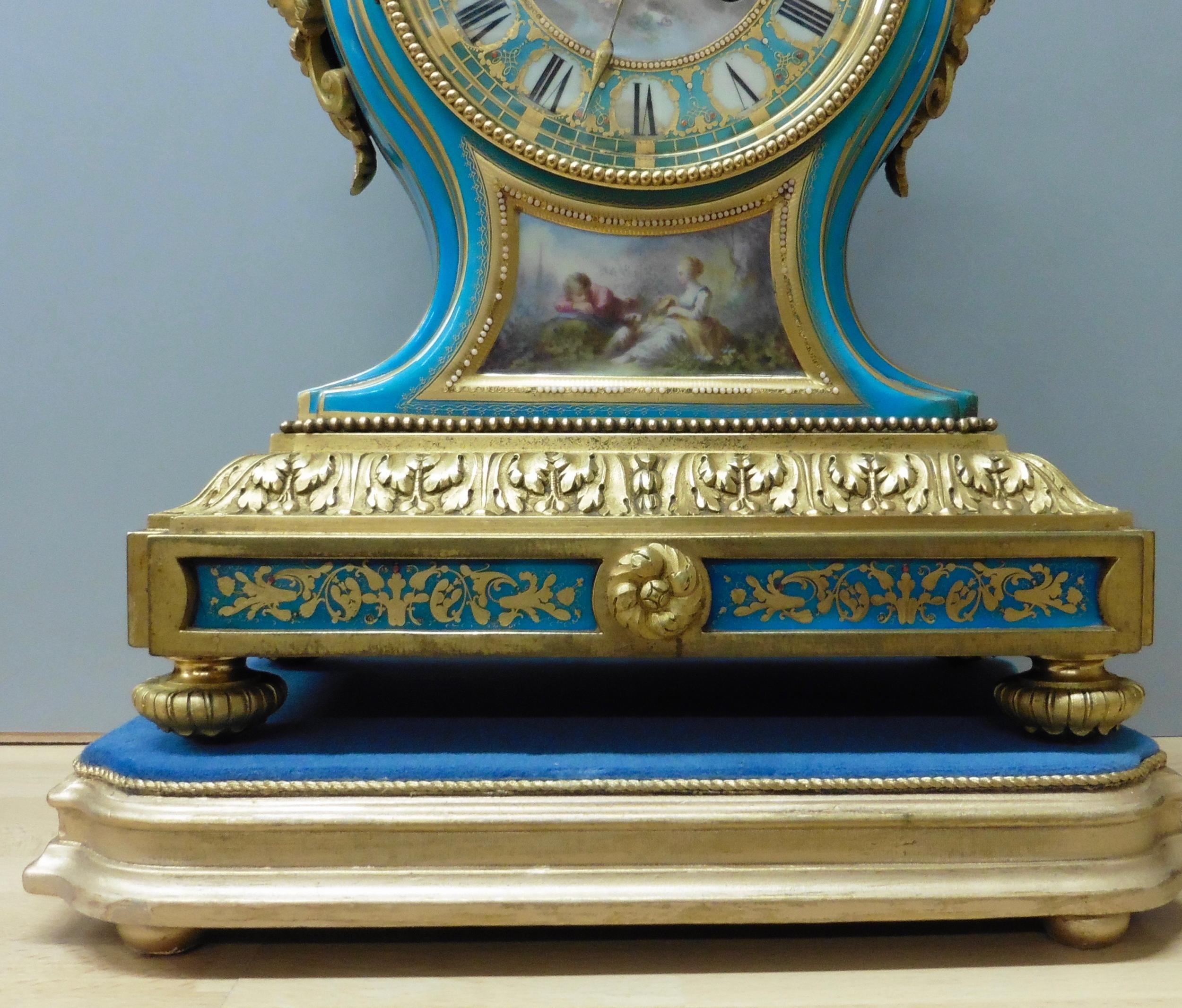 French Porcelain and ormolu mantel clock with gilded toupe feet supporting a raised plinth with an inset blue decorated panel below gilded acanthus moulding.

Turquoise porcelain waisted case with hand painted panel featuring a courting couple