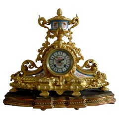 Pendule de cheminée en porcelaine française et en bronze doré avec rehauts d'argent.