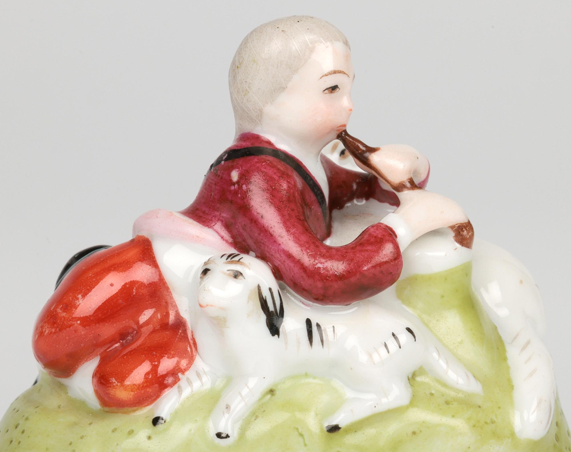 A delightful antique French figural shepherd with sheep metal mounted porcelain bonbonniere dating from the early 19th century. The bonbonniere is of oval shape and has a brass hinged mount which comprises of a flat mounted porcelain oval disk