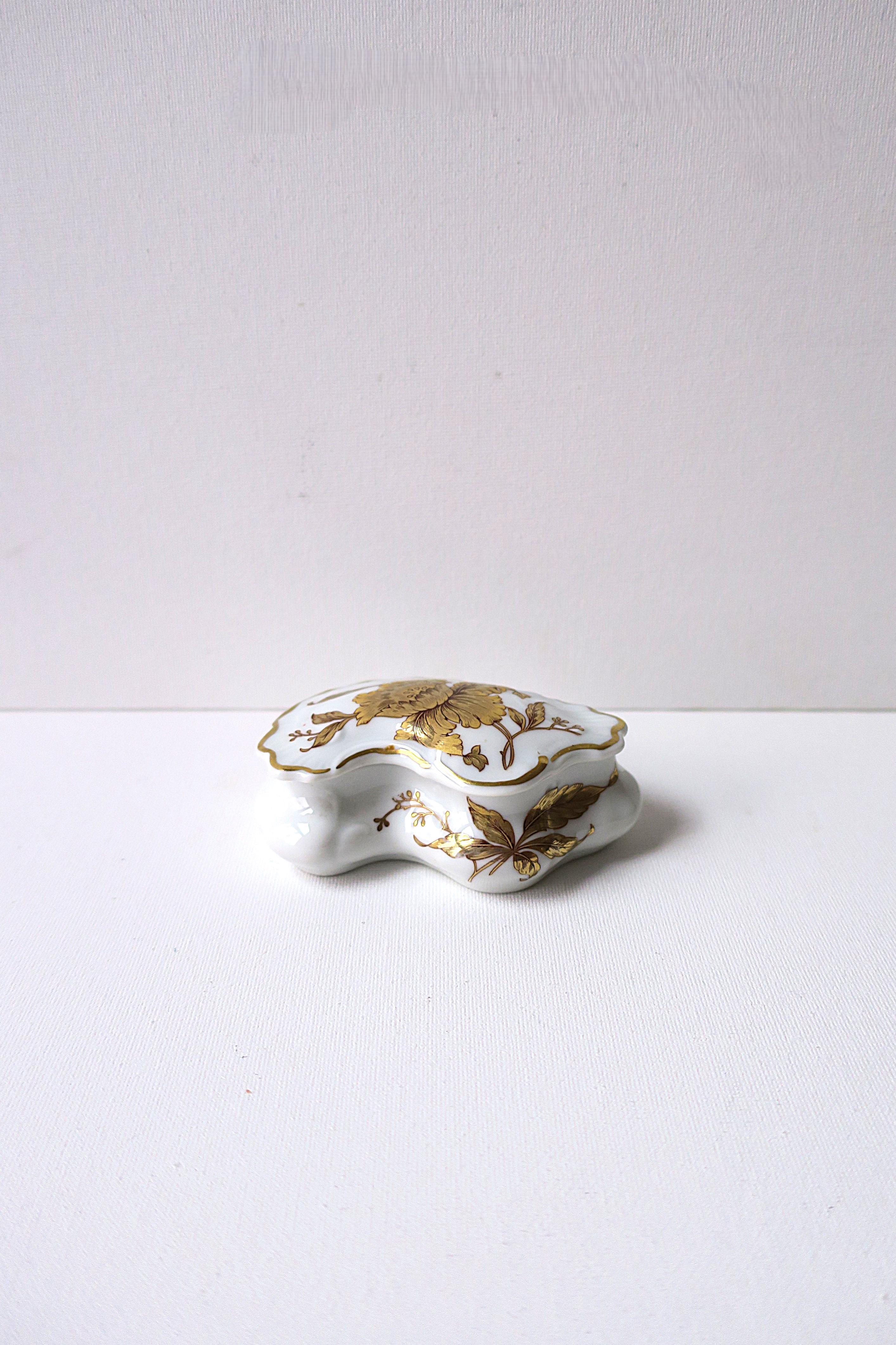 A French porcelain jewelry box with gold flower and leaf design, circa early to mid-20th century, France. Beautiful gold detail on top lid and sides. Shown holding three cocktail rings (all available separately.) A great piece to hold jewelry or