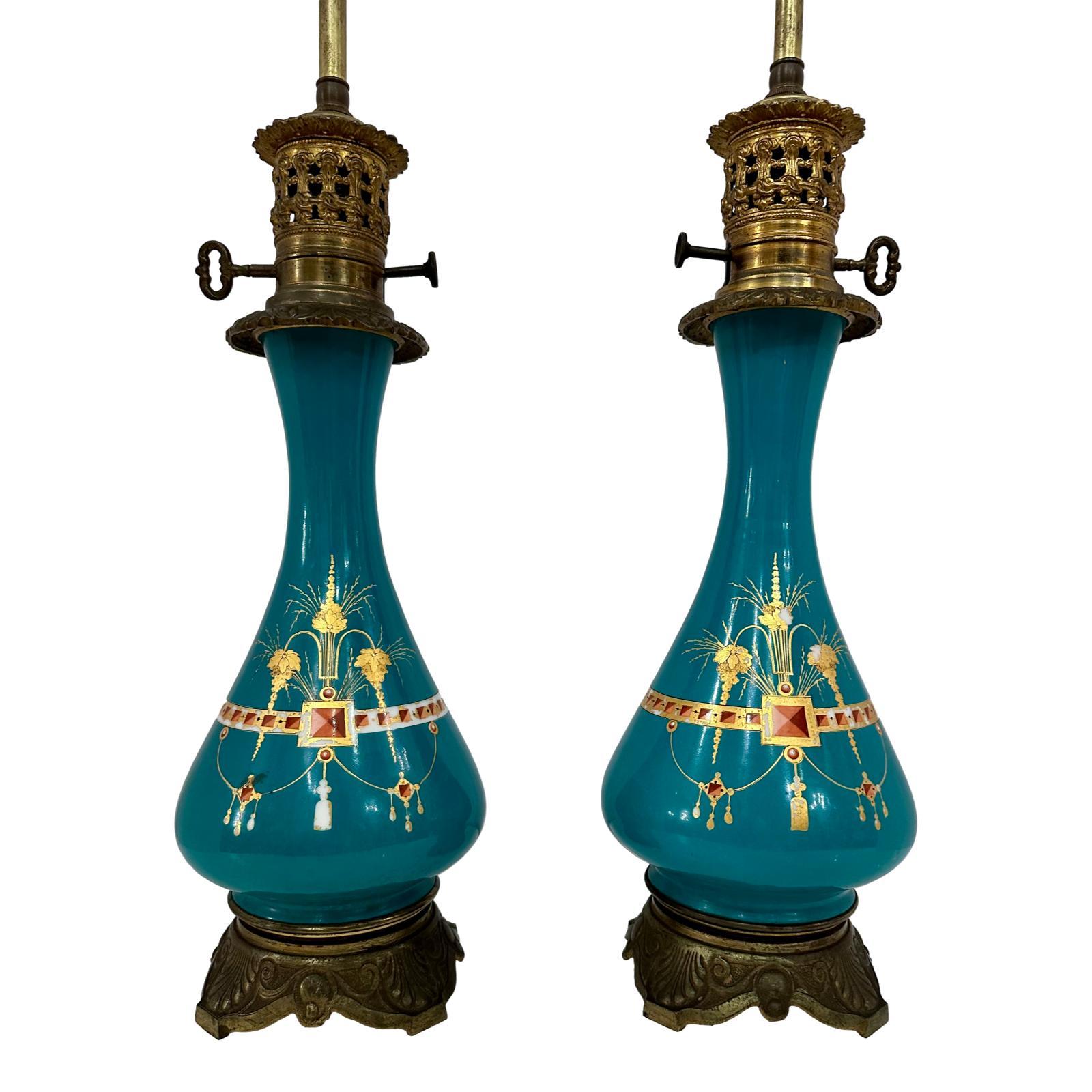 Pair of circa 1900 French green porcelain table lamps with painted and gilt neoclassic decoration on body and bronze bases.

Measurements:
Height of body: 17.5