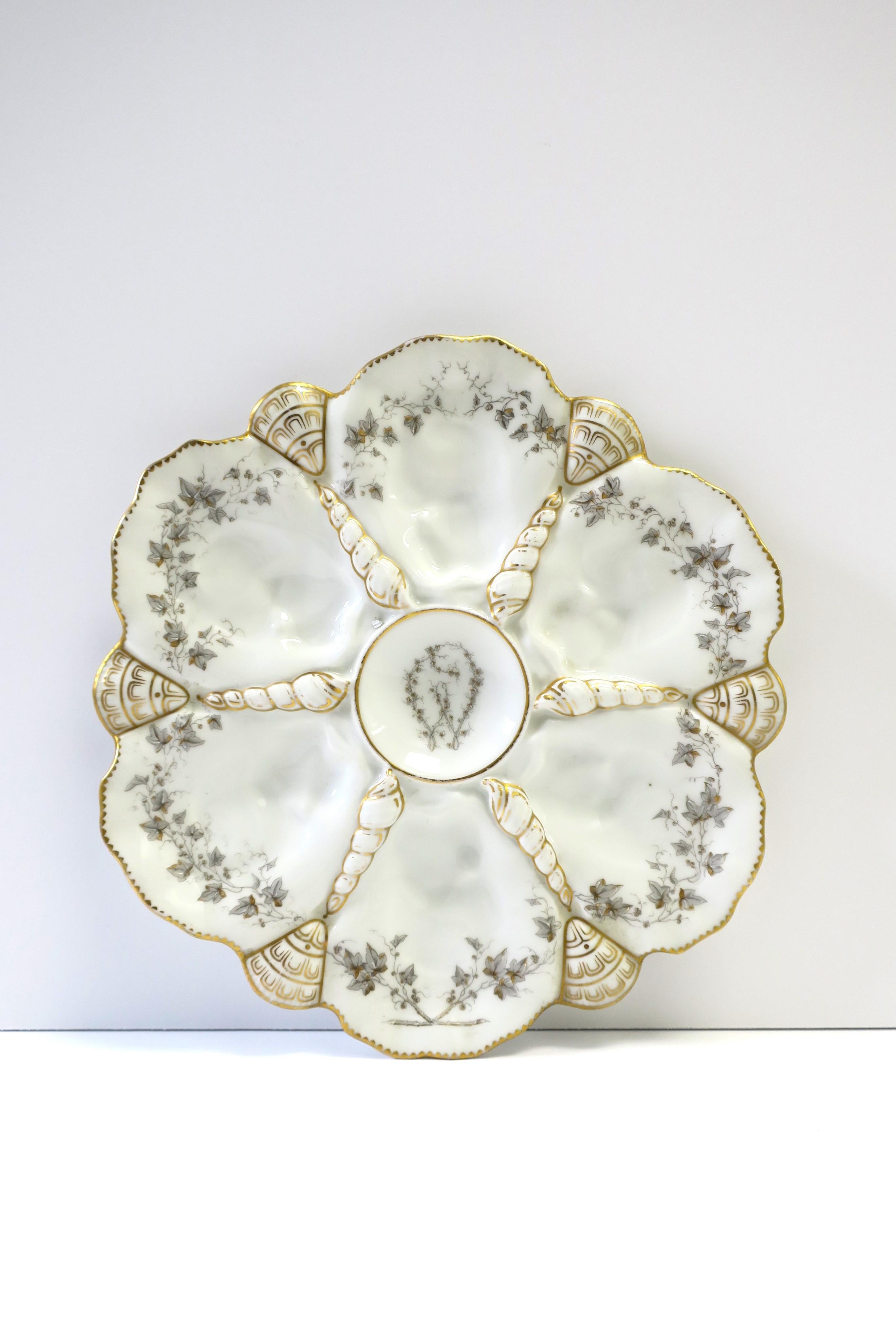 A French white porcelain oyster plate with seashell design and gold gilt detail, circa ealry-20th century, France. A beautiful plate to hold oysters or hang as wall art. Maker's mark on underside as shown, 'Mansard 34 Rue Paradis,