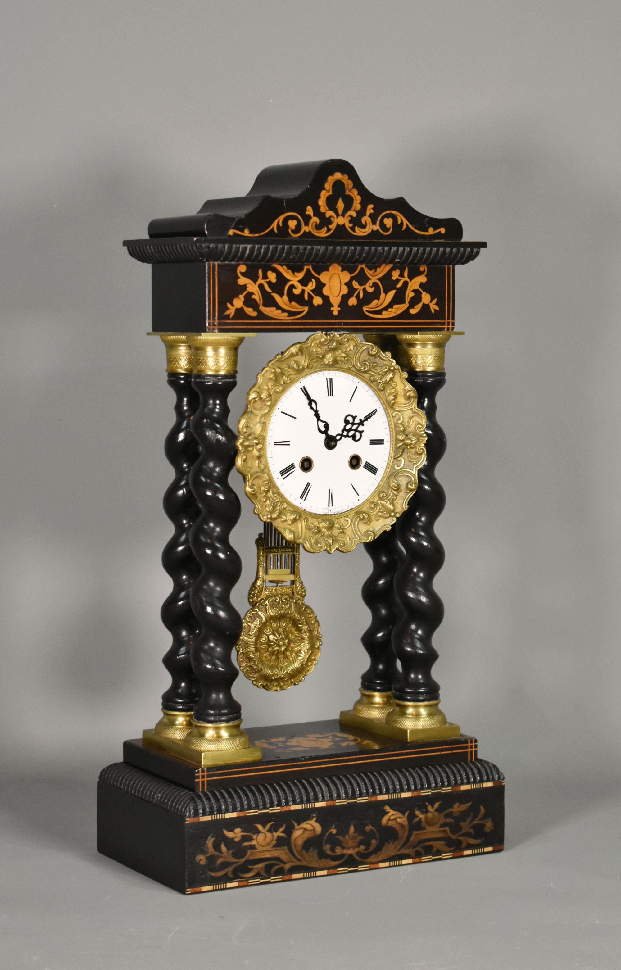 Orologio a torsione d'orzo francese Portico Napoleone III 

Orologio da portico del XIX secolo con intarsi floreali ed ebanizzati. 

L'orologio presenta un'intricata lavorazione in bronzo nella parte superiore e inferiore delle quattro colonne