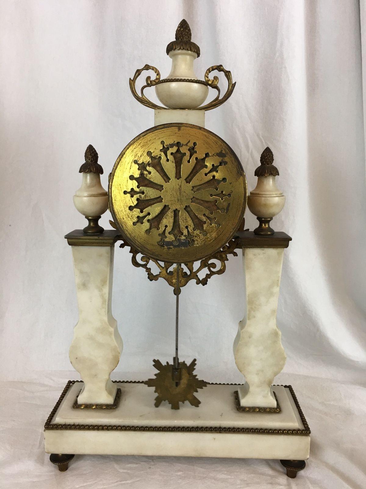Beautiful French portico clock set 

White marble with gilt brass ormolu. Two columns supporting clock, sunburst face pendulum

Roman numerals for hour and Arabic numbers for minutes 

Bosch Honig & Co. Utrecht, possibly retailer 

8 day