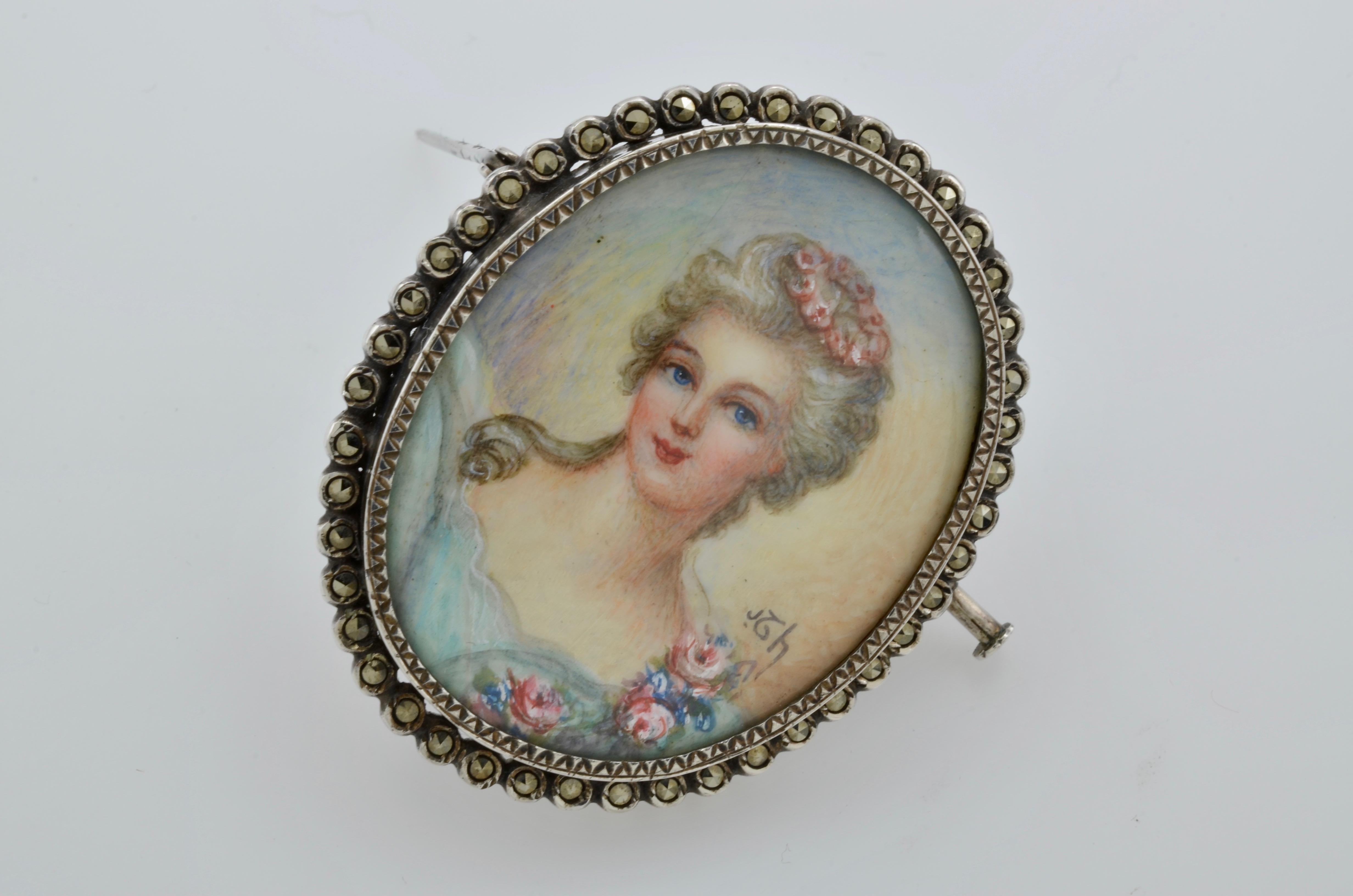 This French hand painted portrait of a lady brooch was made around the 1850's in the style of the 1700's. A halo of marcasite surrounds this beautiful woman. The delicate detail of the portrait creates an illustrious maiden with rosy cheeks and