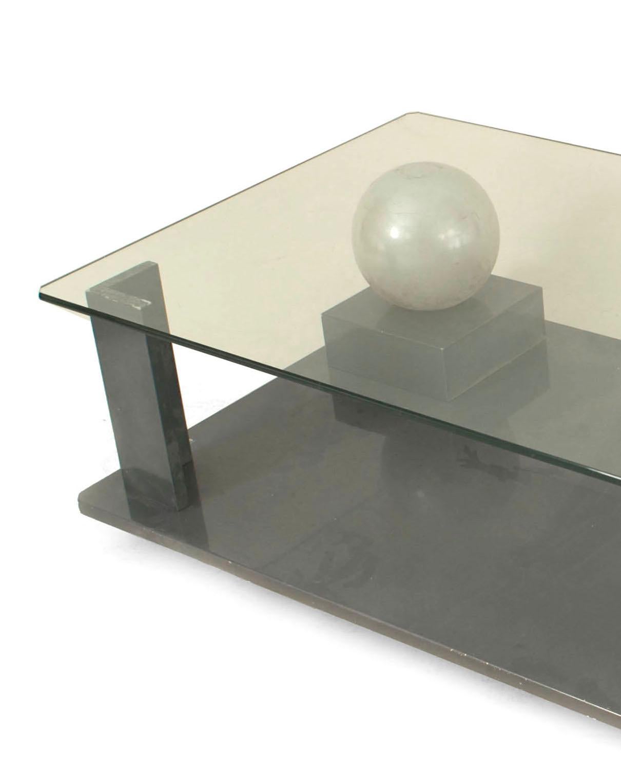 French Mid-Century Modern (1950s) coffee table with a geometric base with two spheres, a lacquered black and gray finish, and a rectangular glass top. (signed with signature etched: CARDIN)
